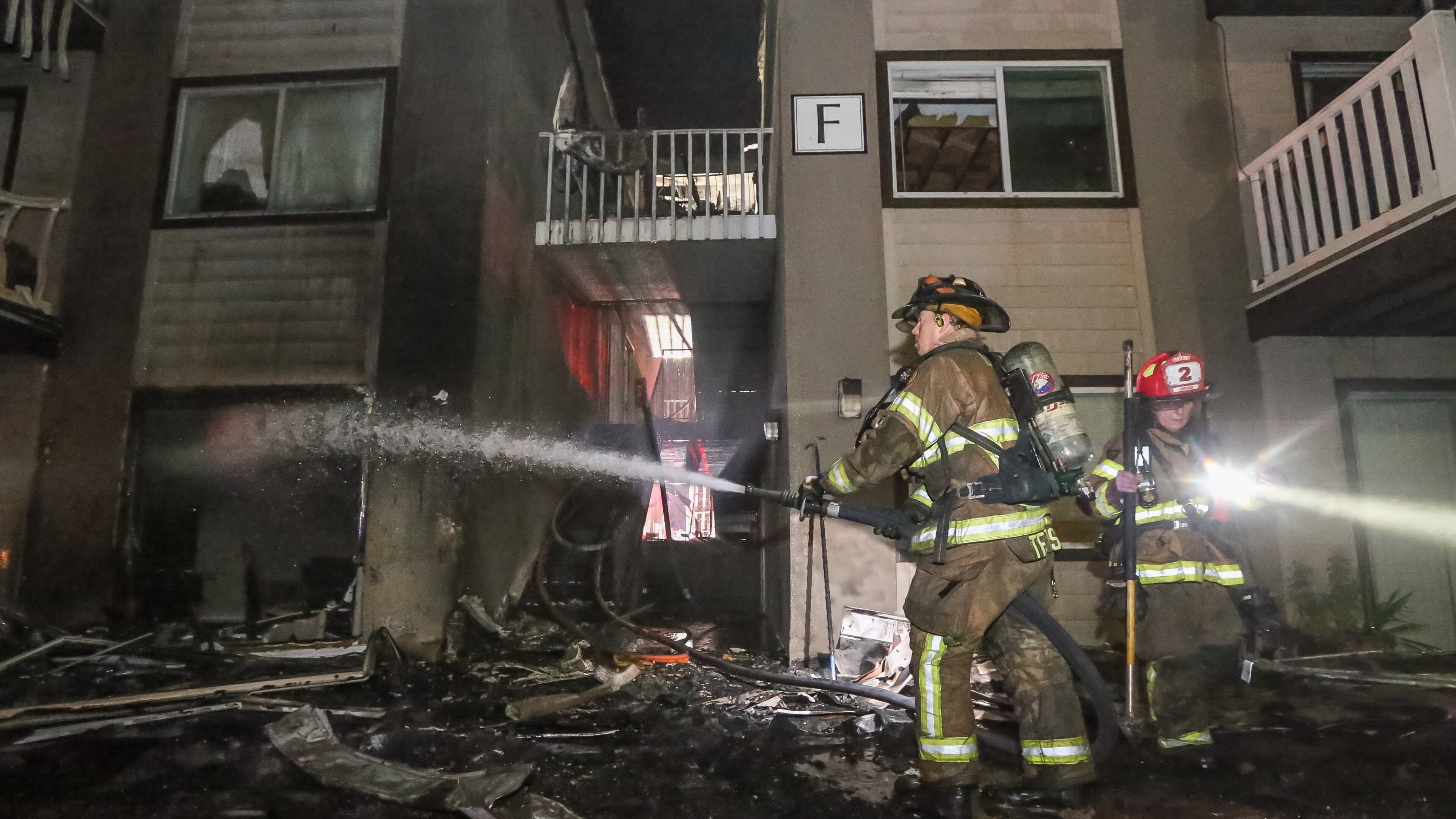 Firefighters worked to extinguish a blaze that destroyed two buildings at the Ashford Gardens apartments Tuesday in DeKalb County. JOHN SPINK / JSPINK@AJC.COM