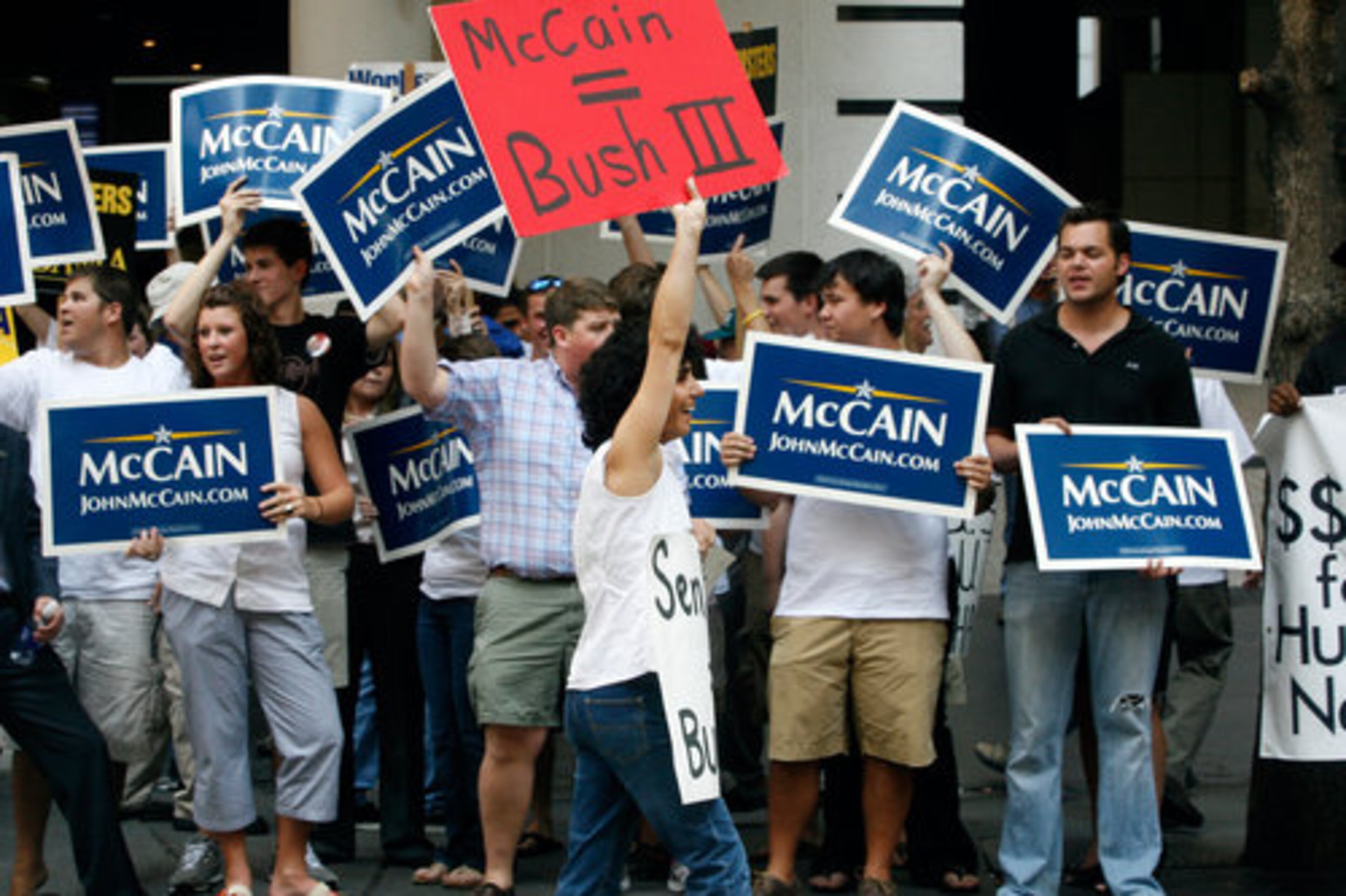 Azita Ebrahimi (center) protests among a group of John McCain supporters along Peachtree Center Avenue in front of the Marriott Marquis.
