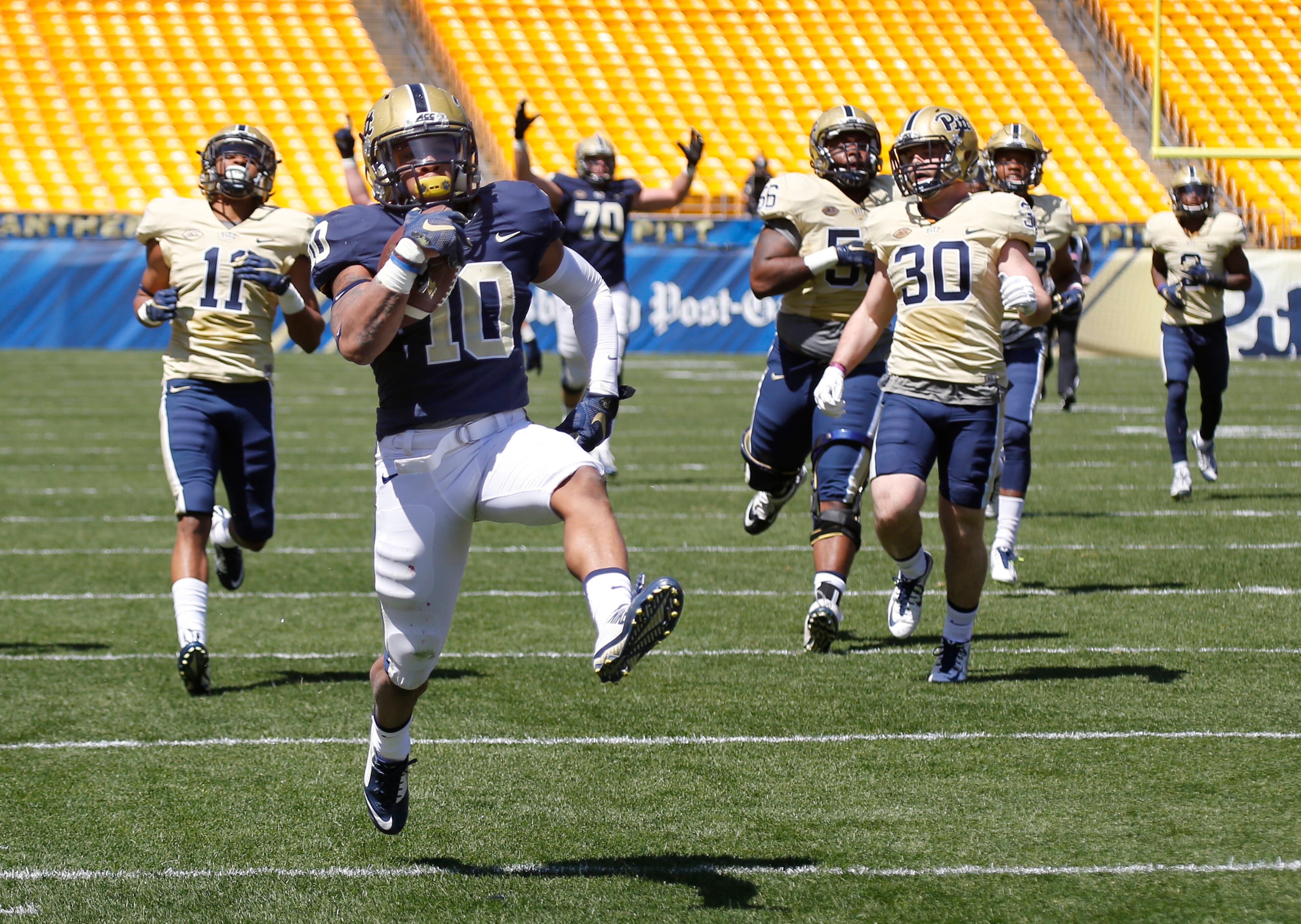 Pittsburgh wide receiver Quadree Henderson (10) dashes past linebacker Mike Caprara (30), defensive back Dane Jackson (11) and the rest of the Gold defense on his way to a touchdown run of over 60 yards on a reverse in the first half of their spring NCAA college football game, Saturday, April 16, 2016 in Pittsburgh. (AP Photo/Keith Srakocic)