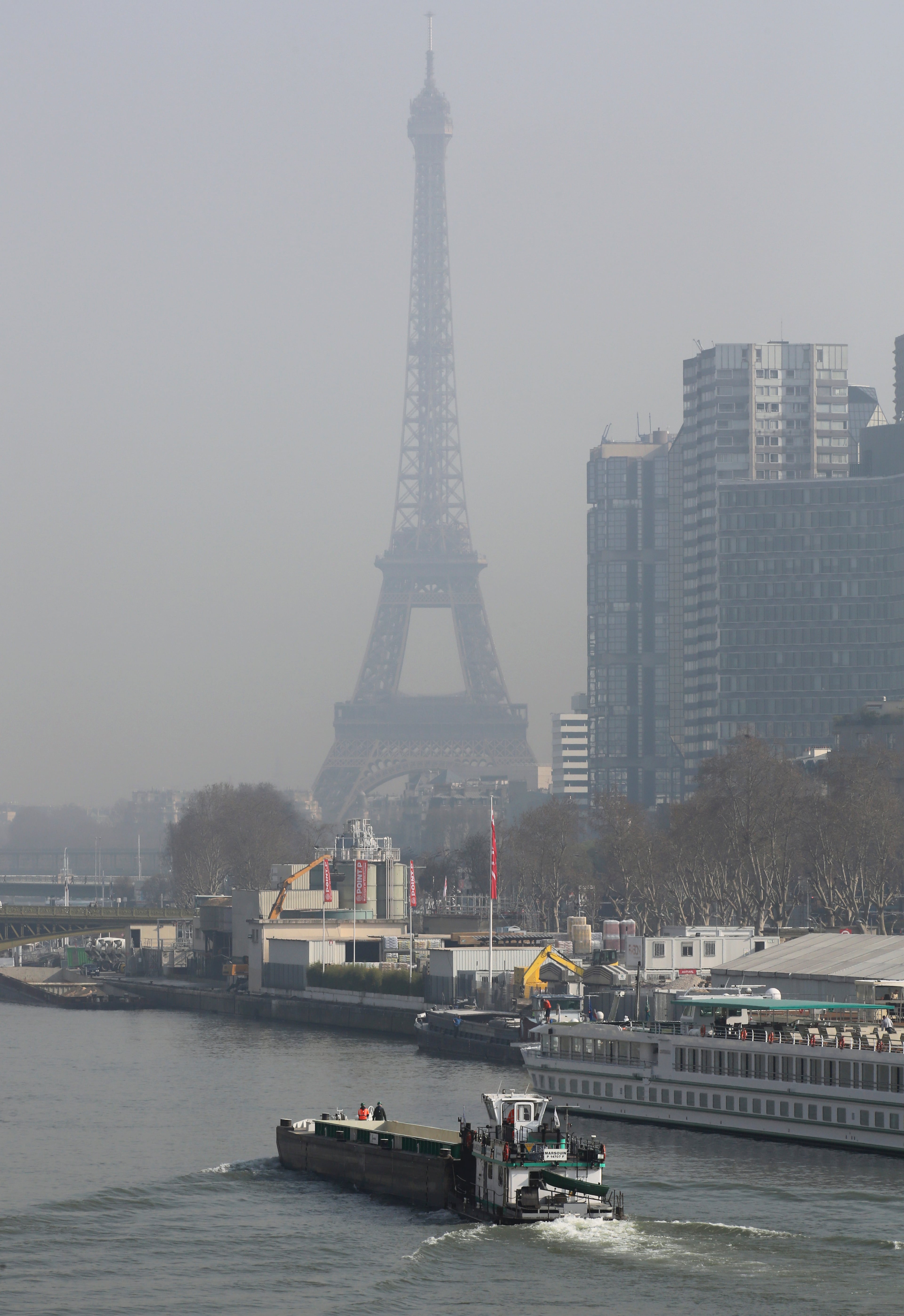 The Eiffel Tower and the Beaugrenelle district, right, are seen through the smog in Paris, Thursday March 13, 2014, as pollution over the French capital is at high levels.