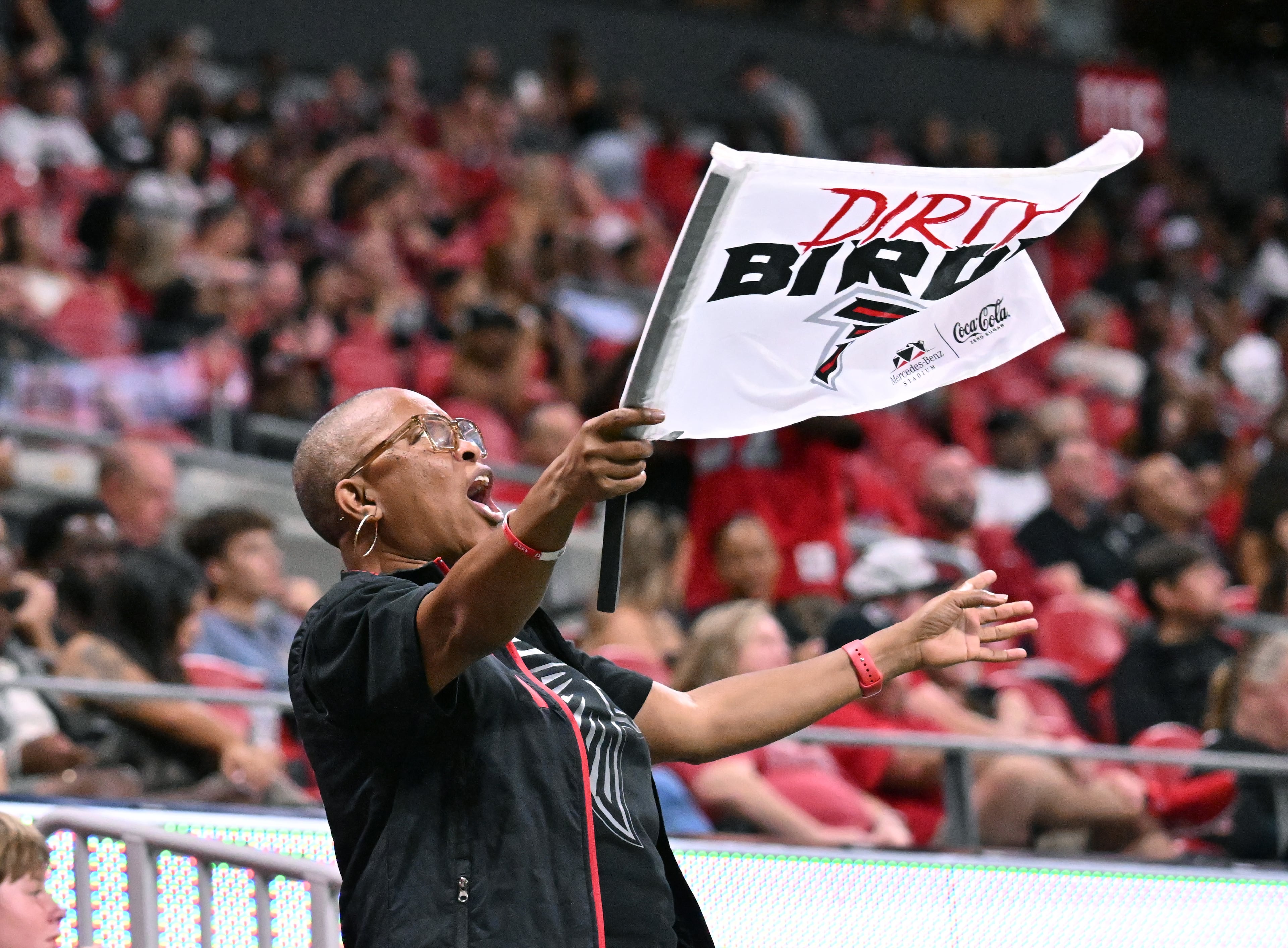 Atlanta Falcons fan waves a flag during the second half of an NFL preseason game at Mercedes-Benz Stadium, Friday, August 15, 2025, in Atlanta. The Tennessee Titans won 23-20 over the Atlanta Falcons. (Hyosub Shin/AJC)
