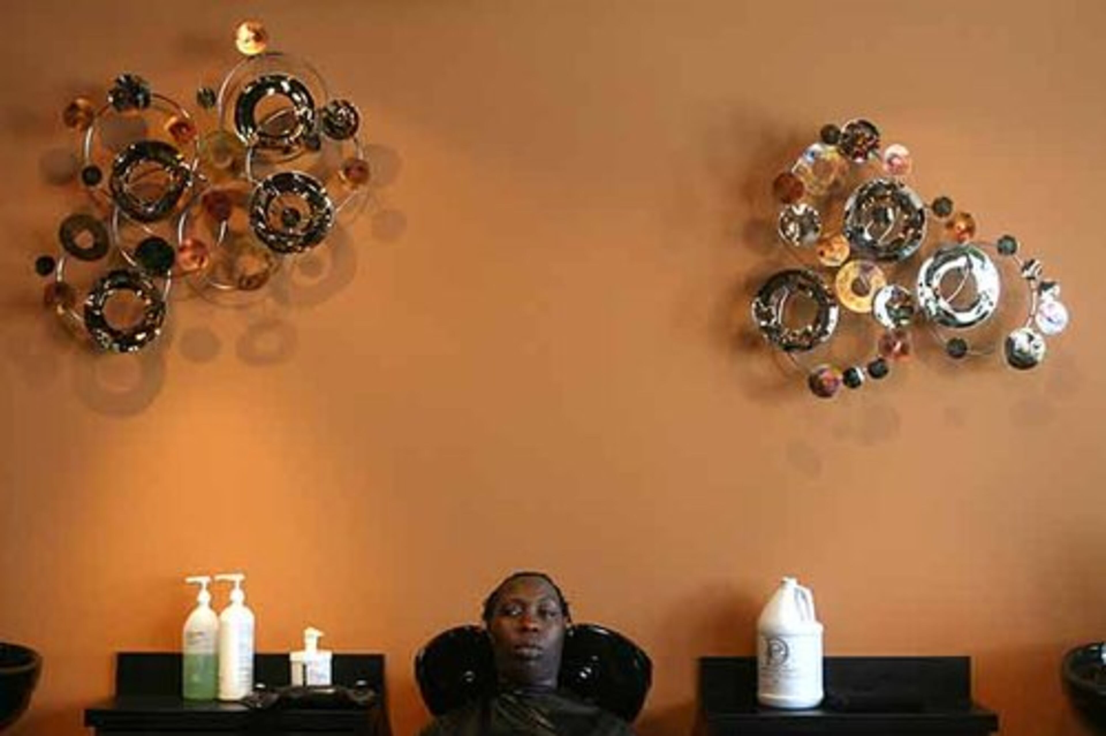 Erin Shepherd, a mother of two, relaxes at the sink after a shampooing at Like the River. Shepherd said her husband can't wait to see her new look, but most of all she was excited because "mothers need pampering, too."