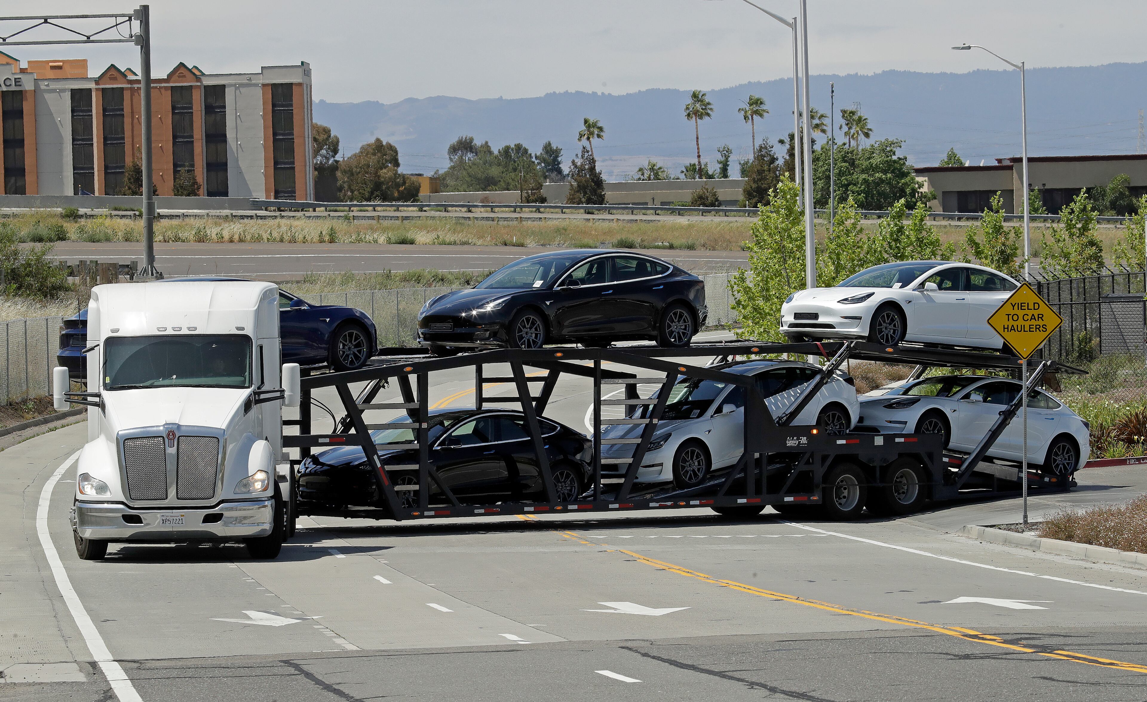 A truck hauling new Tesla vehicles leaves the factory plant Monday.