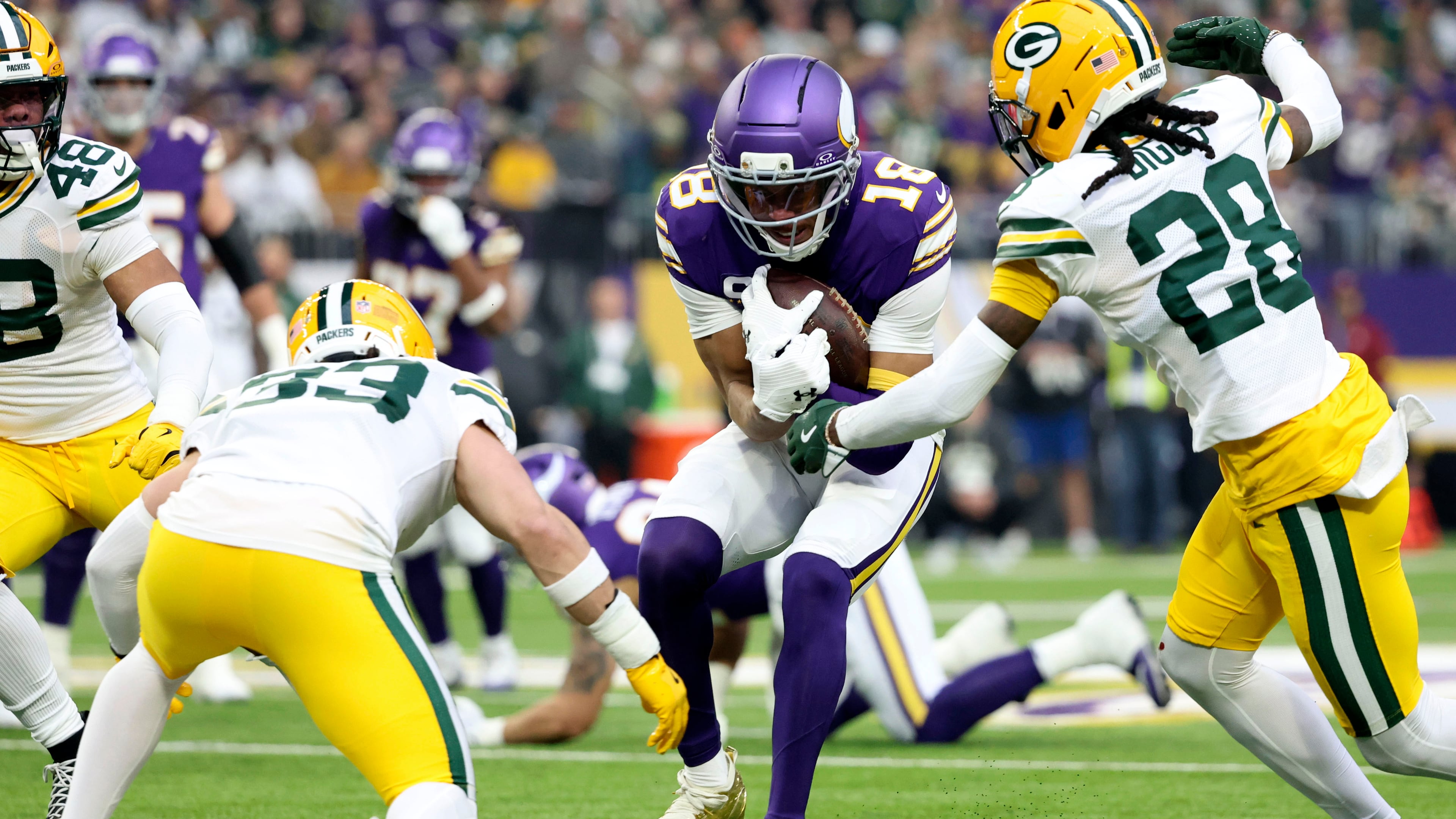Minnesota Vikings wide receiver Justin Jefferson (18) is tackled by Green Bay Packers safety Evan Williams (33) and cornerback Trevon Diggs (28) after catching a pass during the first half of an NFL football game, Sunday, Jan. 4, 2026, in Minneapolis. (AP Photo/Ellen Schmidt)