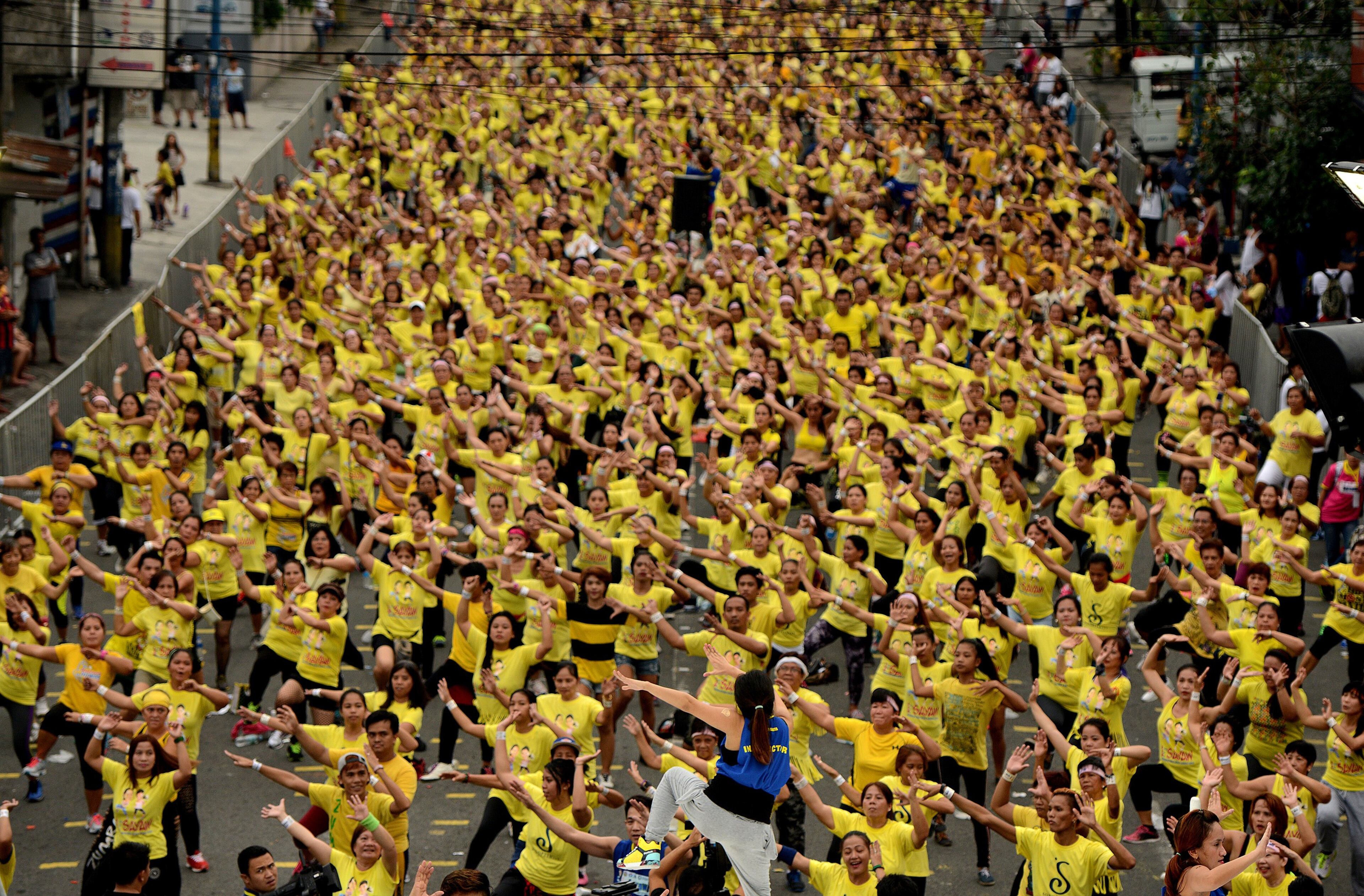 Largest Zumba class - Filipino residents participate in a Zumba class in an attempt to break the Guinness World Record in Mandaluyong on July 19, 2015. Residents broke the record for the largest Zumba class with 12,975 participants in a single venue. AFP PHOTO / NOEL CELIS (Photo credit should read NOEL CELIS/AFP/Getty Images)