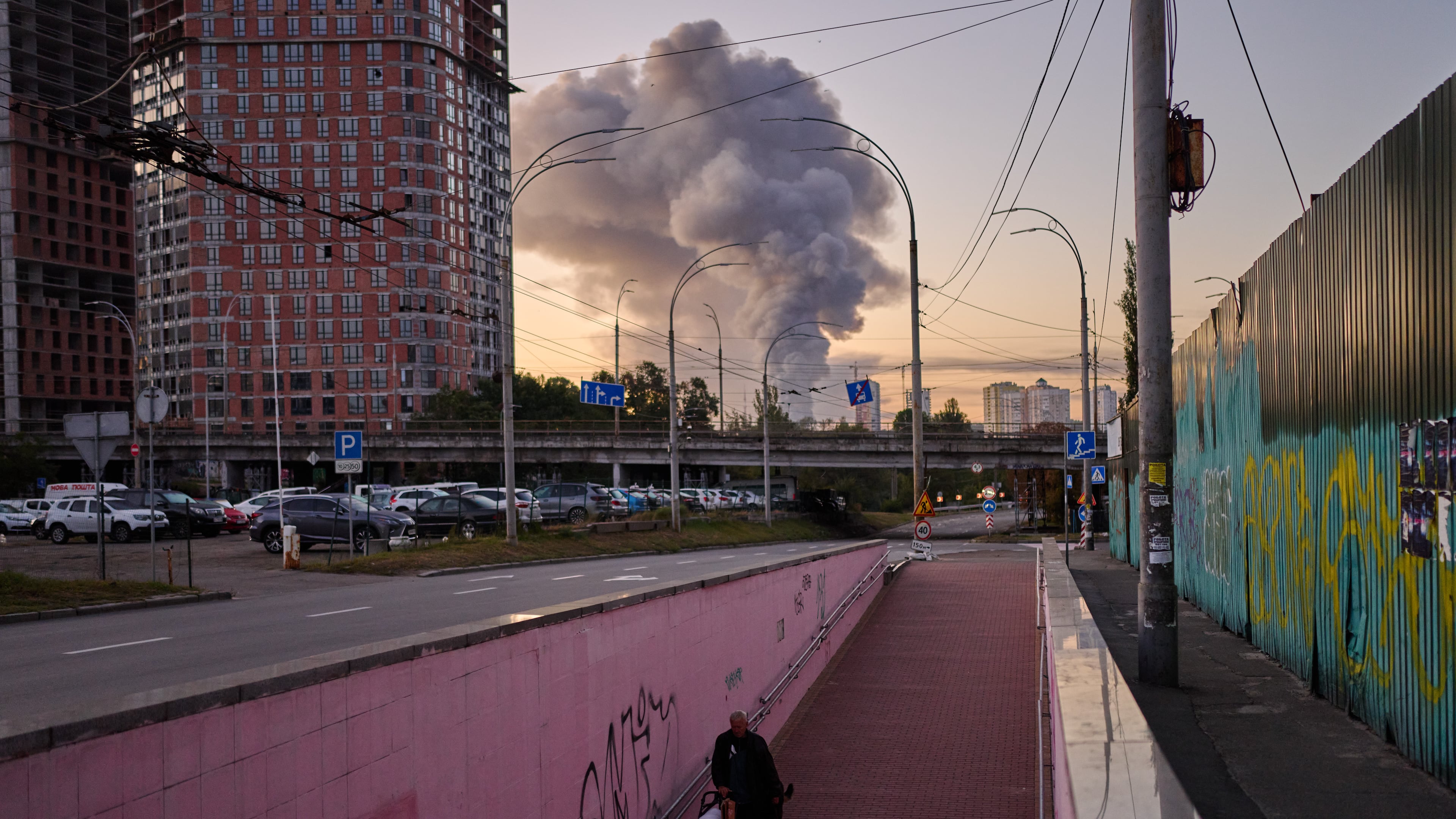 A man walks along an underpass as smoke rises following a Russian missile attack in Kyiv, Ukraine, early Tuesday, Sept. 8, 2026. (AP Photo/Francisco Seco)