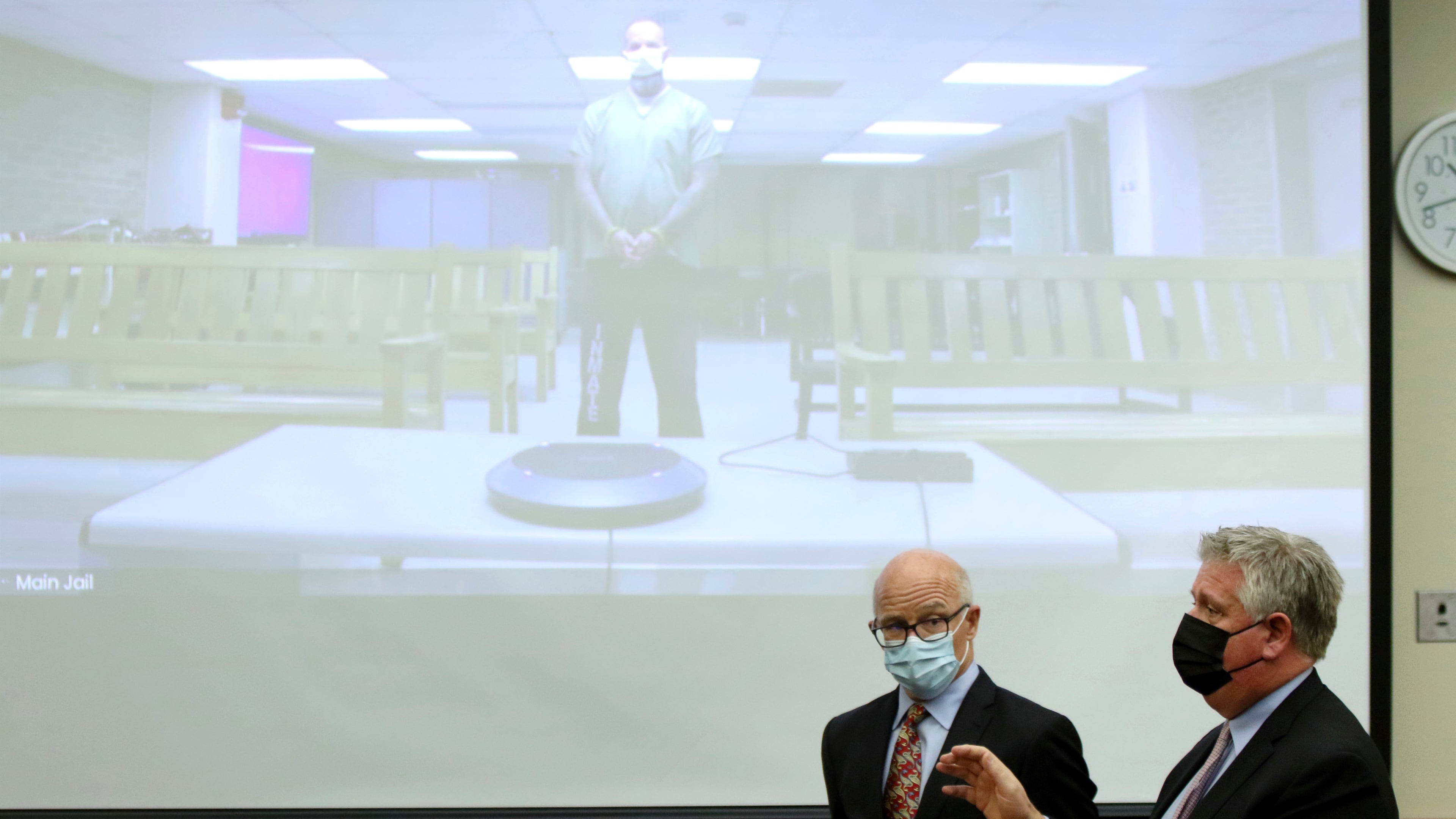 FILE - Defense attorney Mark Collins, right, speaks to the judge as defense attorney Steve Nodler, center, listens during the arraignment of former Franklin County, Ohio, deputy Jason Meade, appearing on video screen, Dec. 3, 2021, in Columbus, Ohio. (AP Photo/Paul Vernon, File)
