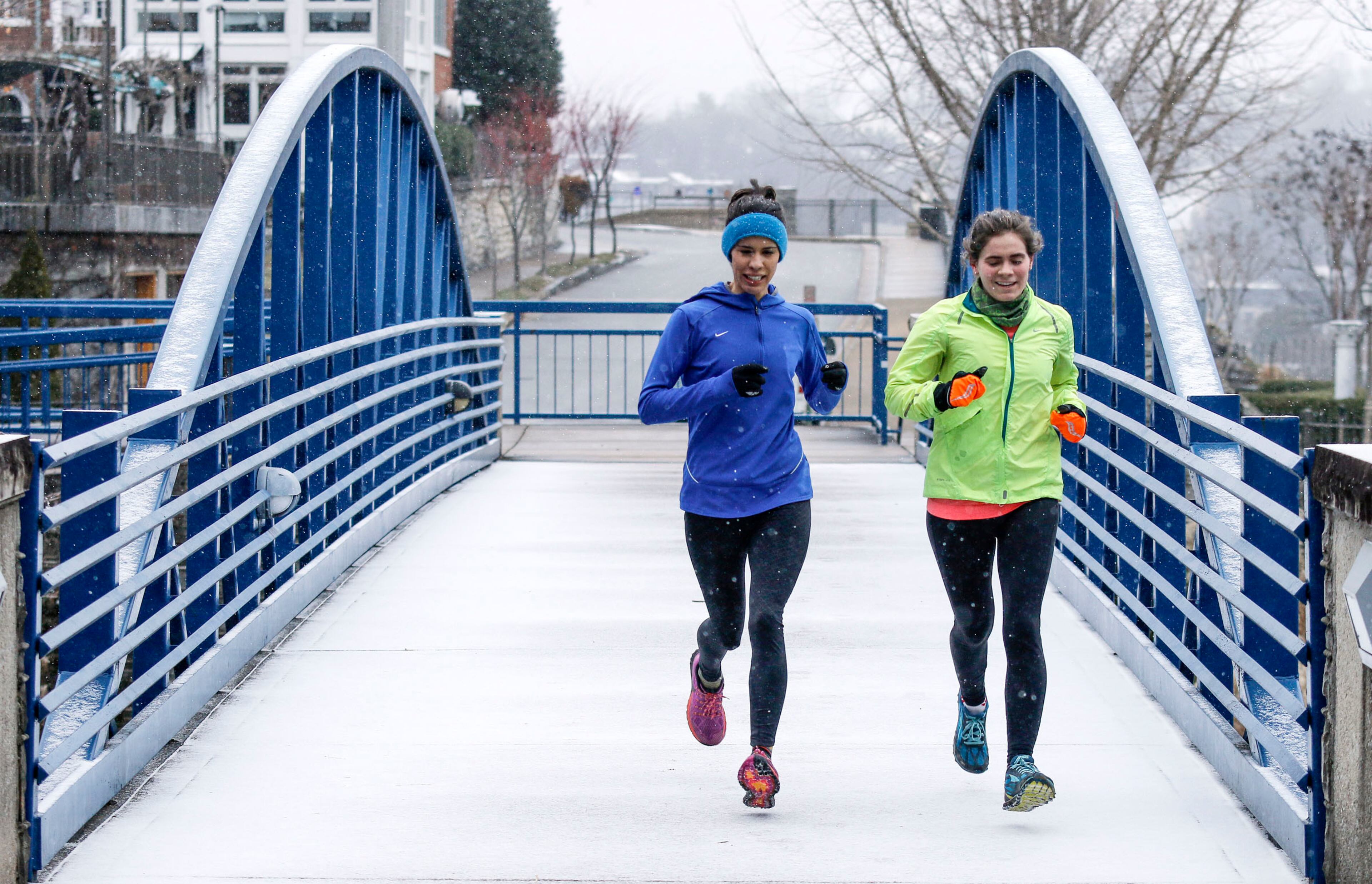 Christina Williams, left, and Katie Robinson jog on the riverwalk in the snow downtown on Tuesday, Jan. 16, 2018, in Chattanooga, Tenn. A winter storm brought snow, ice and frigid temperatures to the region and much of the Southeast on Tuesday. (Doug Strickland/Chattanooga Times Free Press via AP)