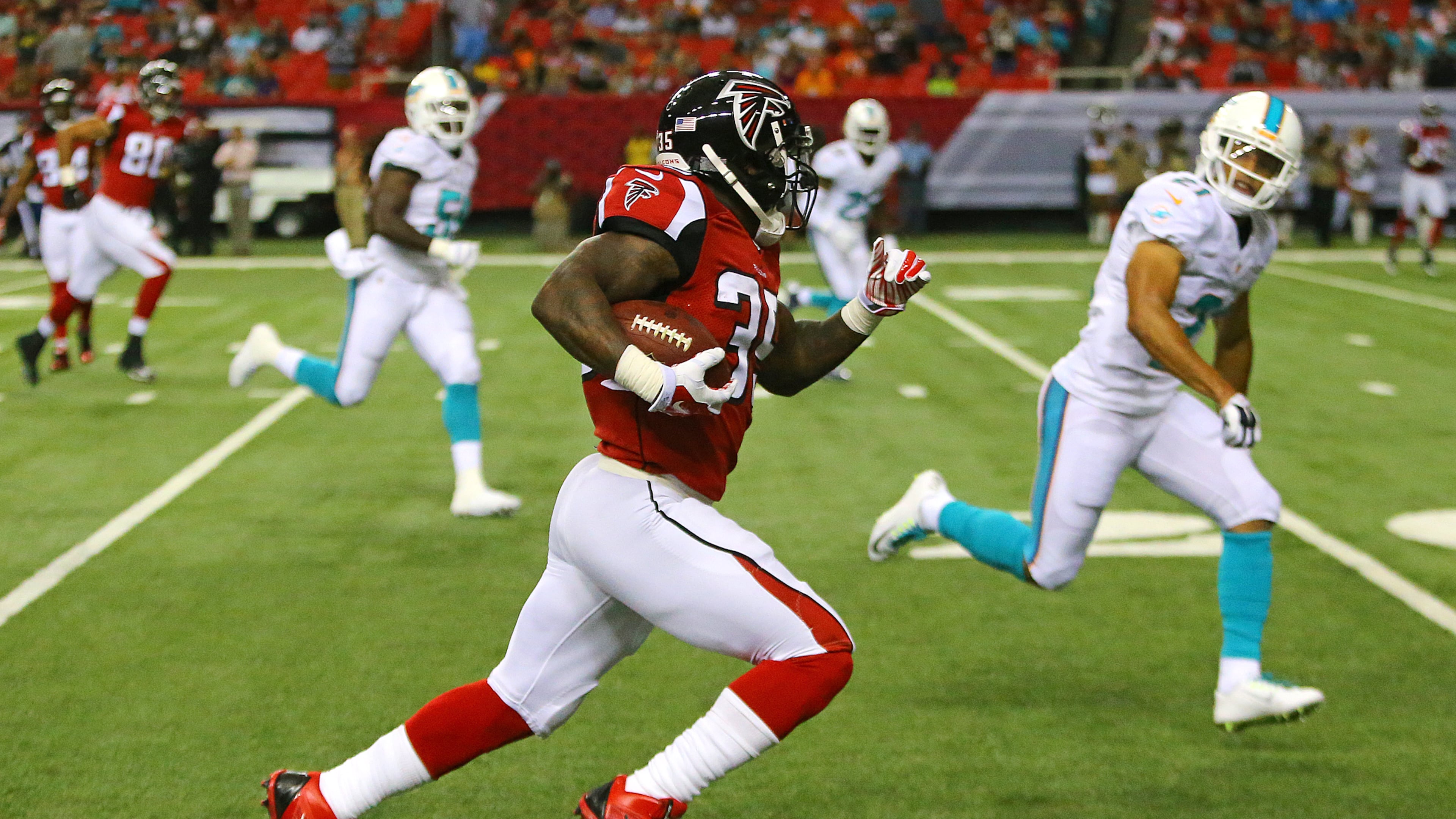 Falcons running back Antone Smith breaks away from Miami defenders for a long gain that was called back for a penalty during their NFL exhibition game on Friday, August 8, 2014, in Atlanta.