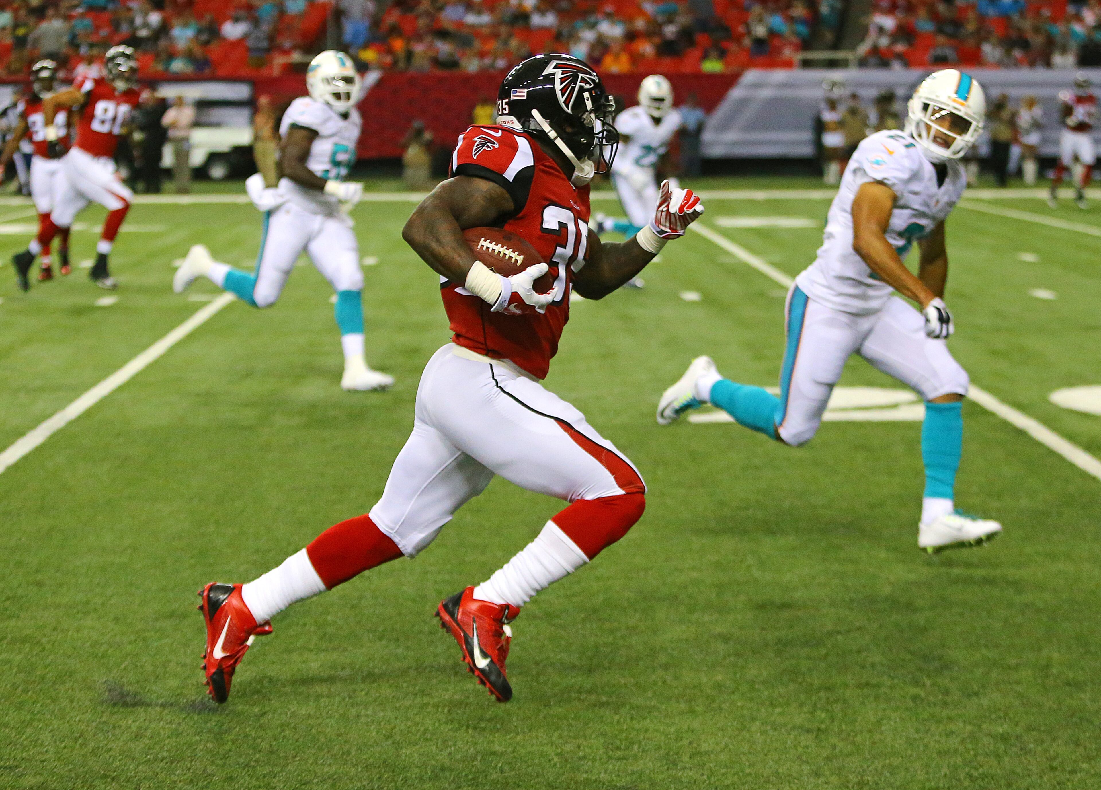 Falcons running back Antone Smith breaks away from Miami defenders for a long gain that was called back for a penalty during their NFL exhibition game on Friday, August 8, 2014, in Atlanta.