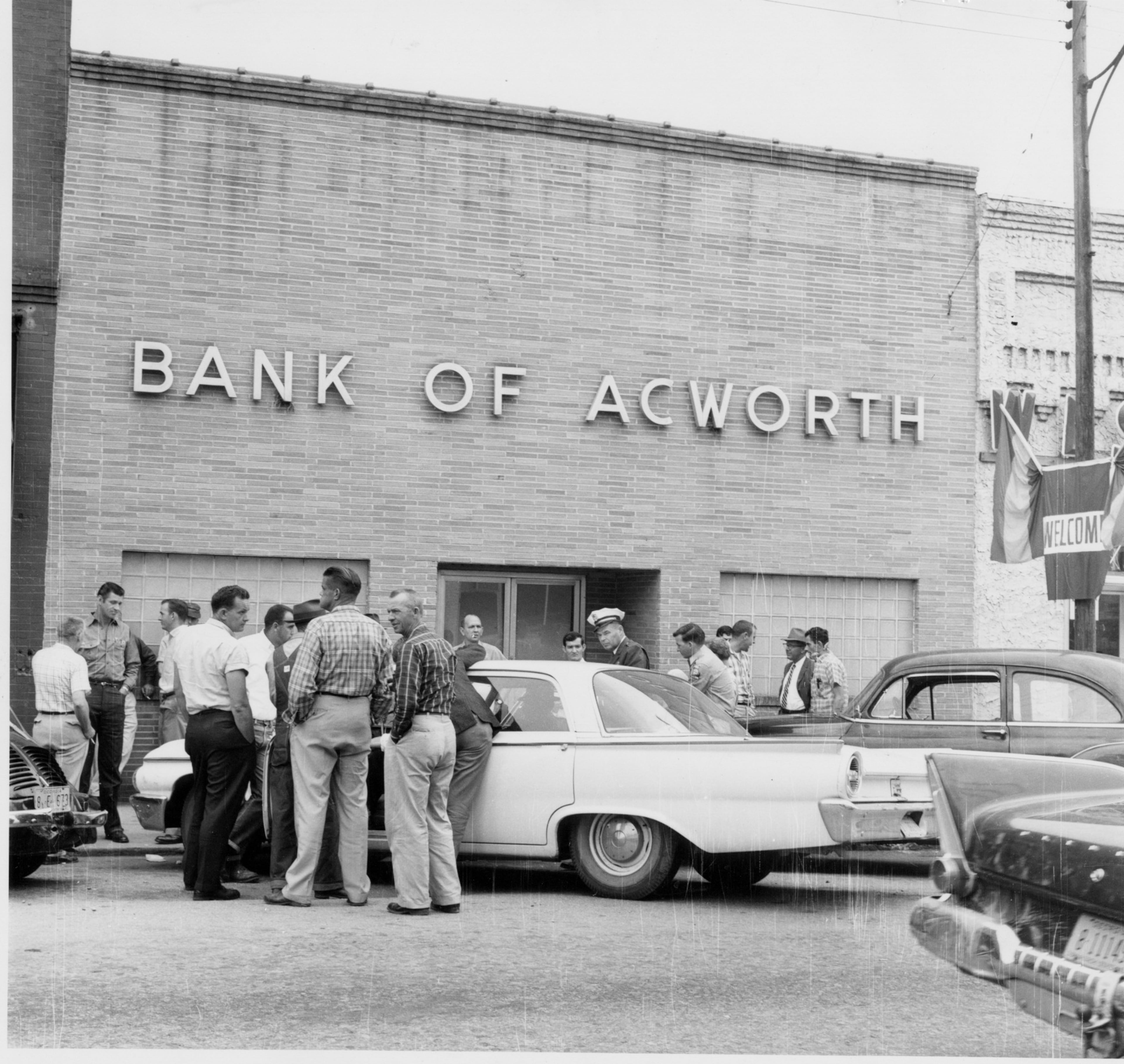 Bystanders gather in front of the Bank of Acworth which was robbed Sept. 19, 1961.