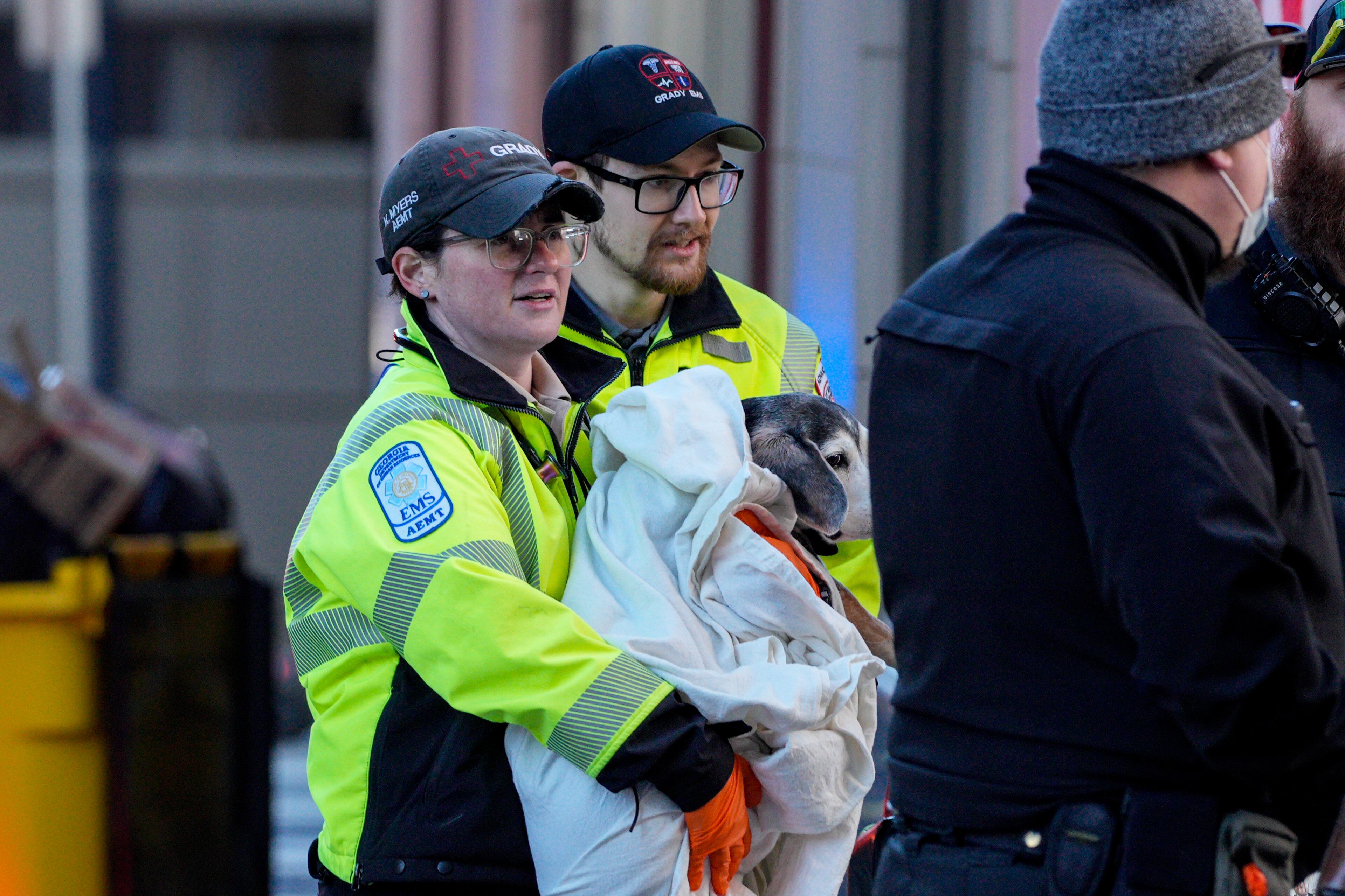 A Grady EMT holds a rescued dog outside of the Residence Inn on Peachtree Street following a hazmat incident inside the hotel. Friday, January 3, 2024 (Ben Hendren for the Atlanta Journal-Constitution)