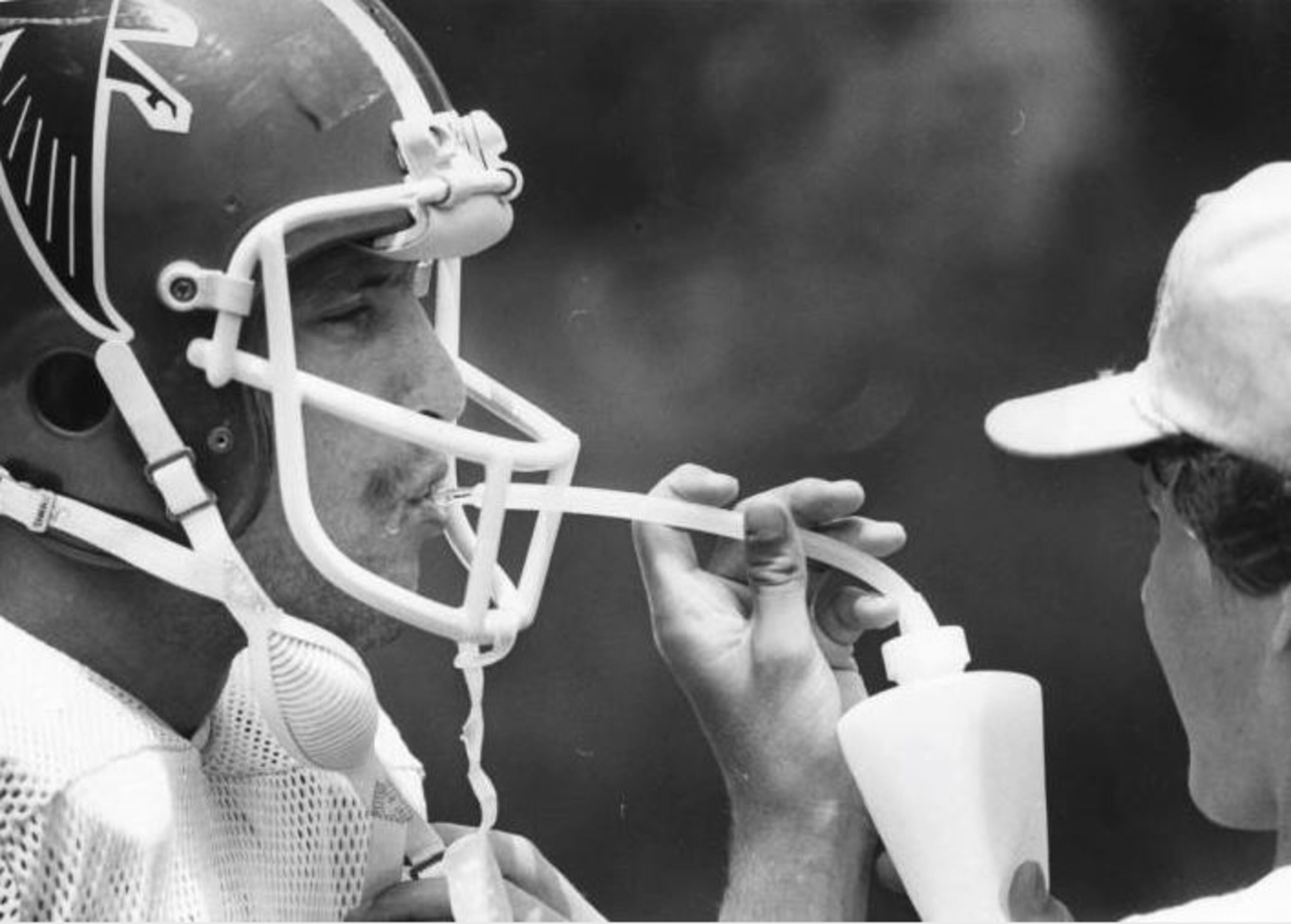 1980 -- The Falcons' David Becker gets a drink of water during team workouts. That year, the Falcons would go 12-4 and finish first in the NFC-West. STEVE DEAL / AJC PHOTO ARCHIVES