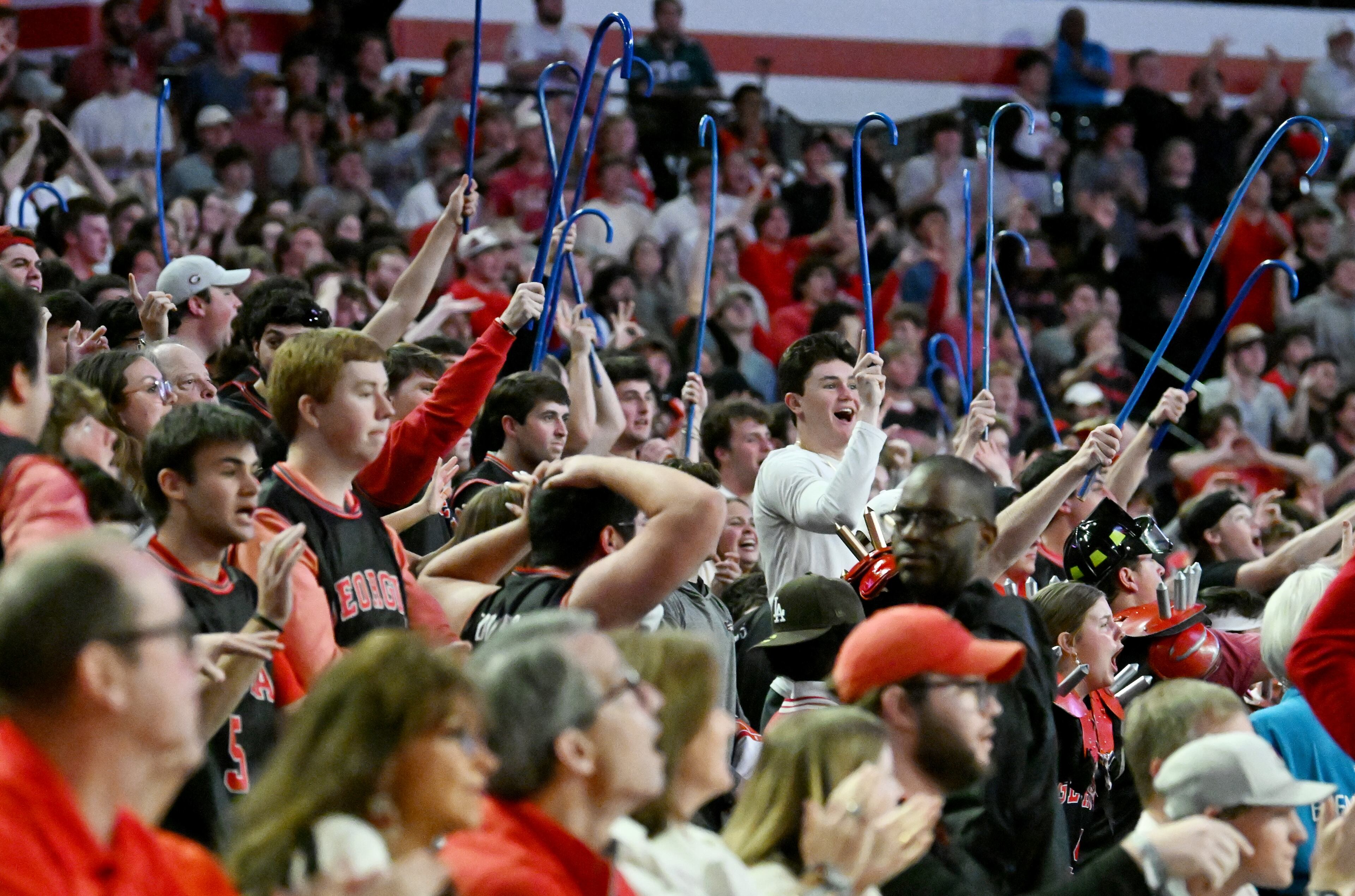 Georgia fans hold blue canes after Georgia guard Blue Cain scored a 3-point basket to lead 80-78 with a minute left during the second half of an NCAA college basketball game at Stegeman Coliseum, Tuesday, February 25, 2025, in Athens. Georgia won 88-83 over Florida. (Hyosub Shin / AJC)