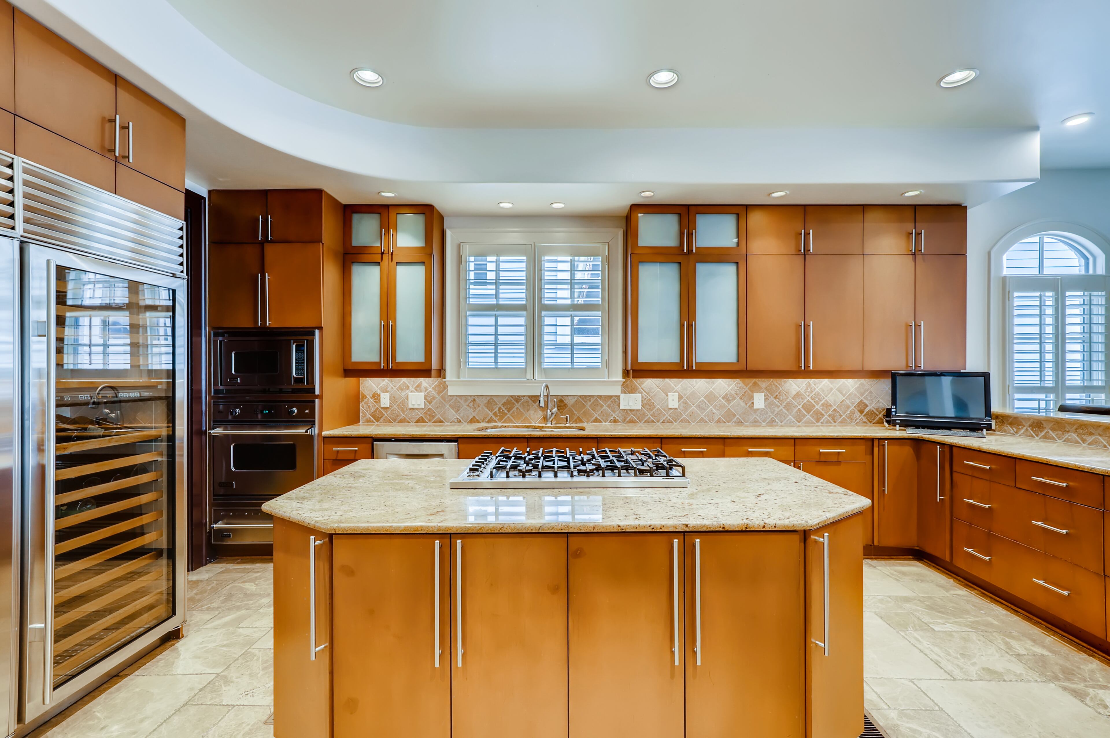 Gourmet kitchen with granite countertops, wine cooler, custom cabinetry and top-of-the-line appliances. Text by Diane Arnold