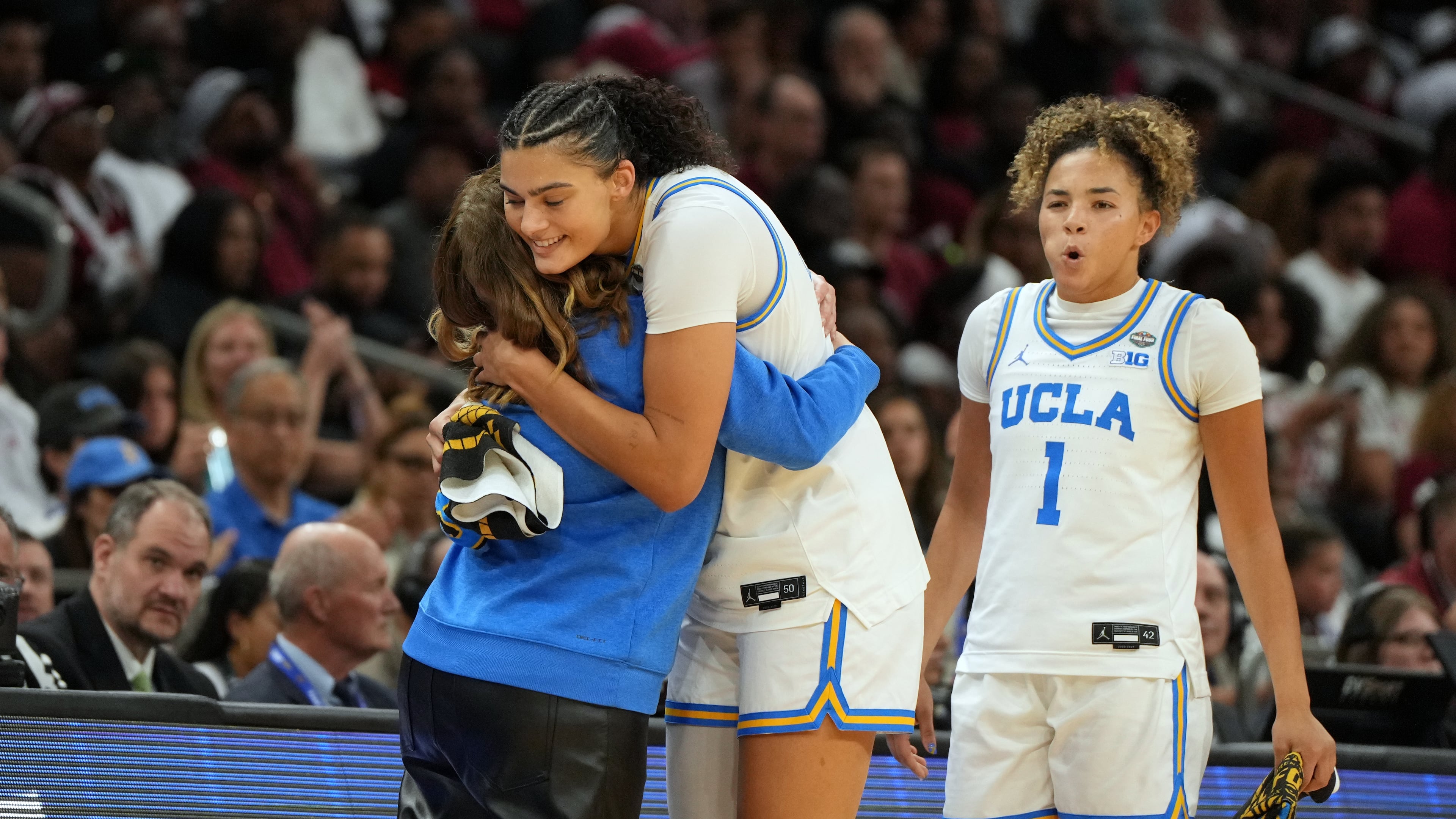 UCLA head coach Cori Close, left, hugs UCLA center Lauren Betts (51) during the second half of the women's National Championship Final Four NCAA college basketball tournament game against South Carolina, Sunday, April 5, 2026, in Phoenix. (AP Photo/Rick Scuteri)
