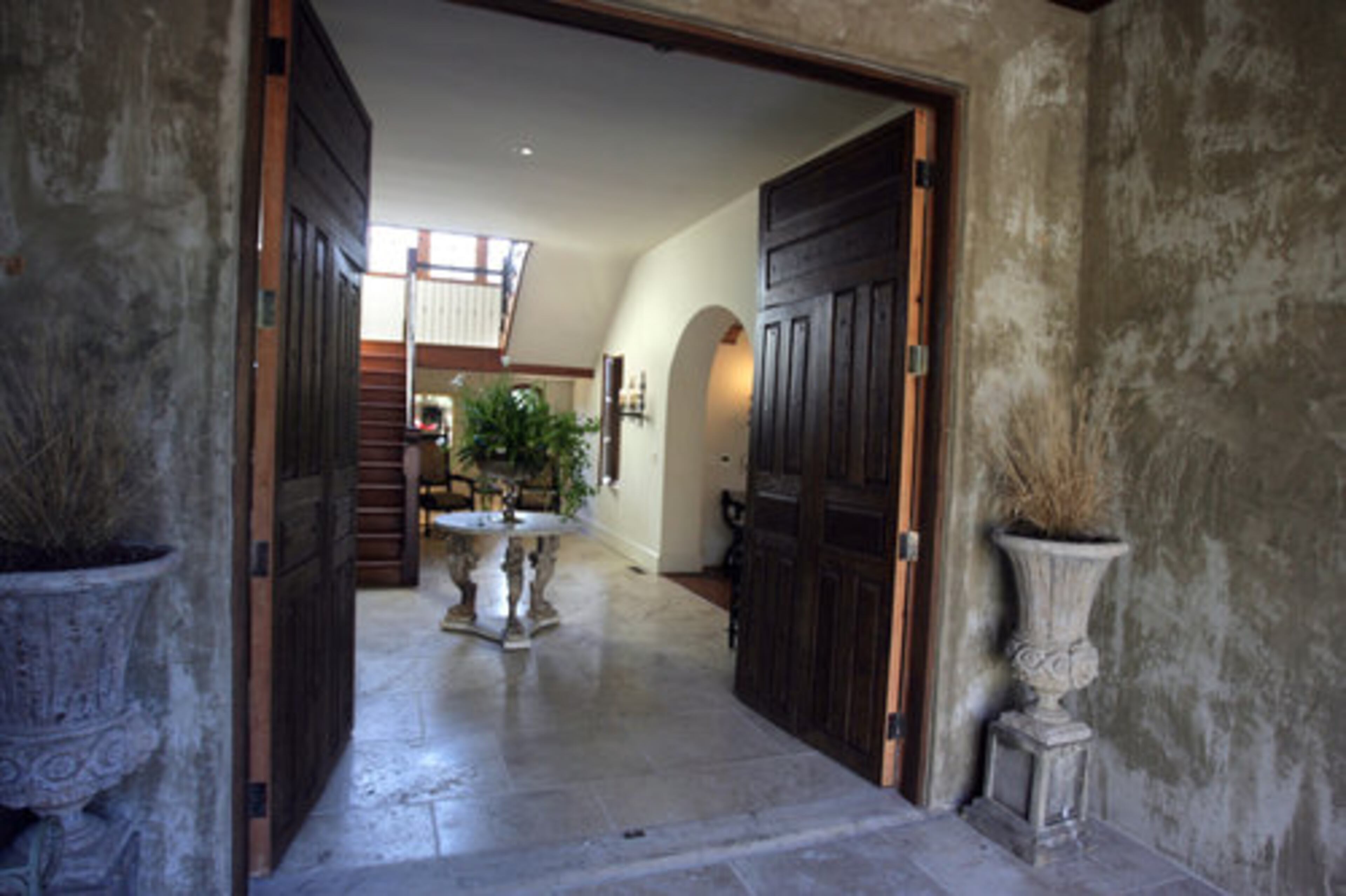 Built with aerated concrete called Hebel block, the material is not only energy efficient but also yields these thick doorways that give the home the look the couple wanted. When fully open, the front doors, which contain smaller doors within them, convert the foyer into a "big indoor/outdoor room, which we do anytime we're entertaining," Meridy says. "When they open, it's like taking out a wall of a house."