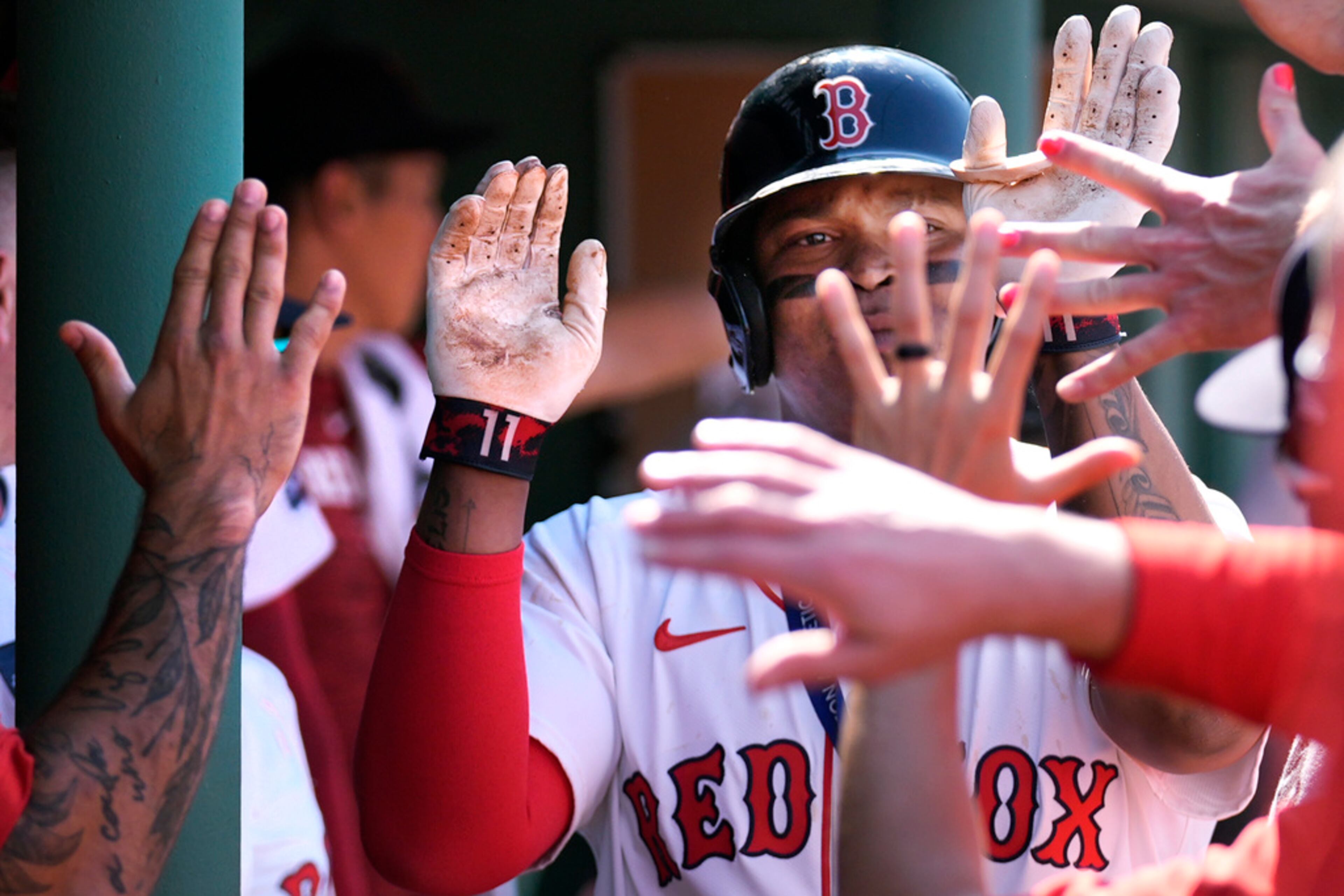 Boston Red Sox's Rafael Devers is congratulated by teammates after hitting a two-run home run in the seventh inning of a baseball game against the Atlanta Braves, Wednesday, June 5, 2024, at Fenway Park in Boston. (AP Photo/Charles Krupa)
