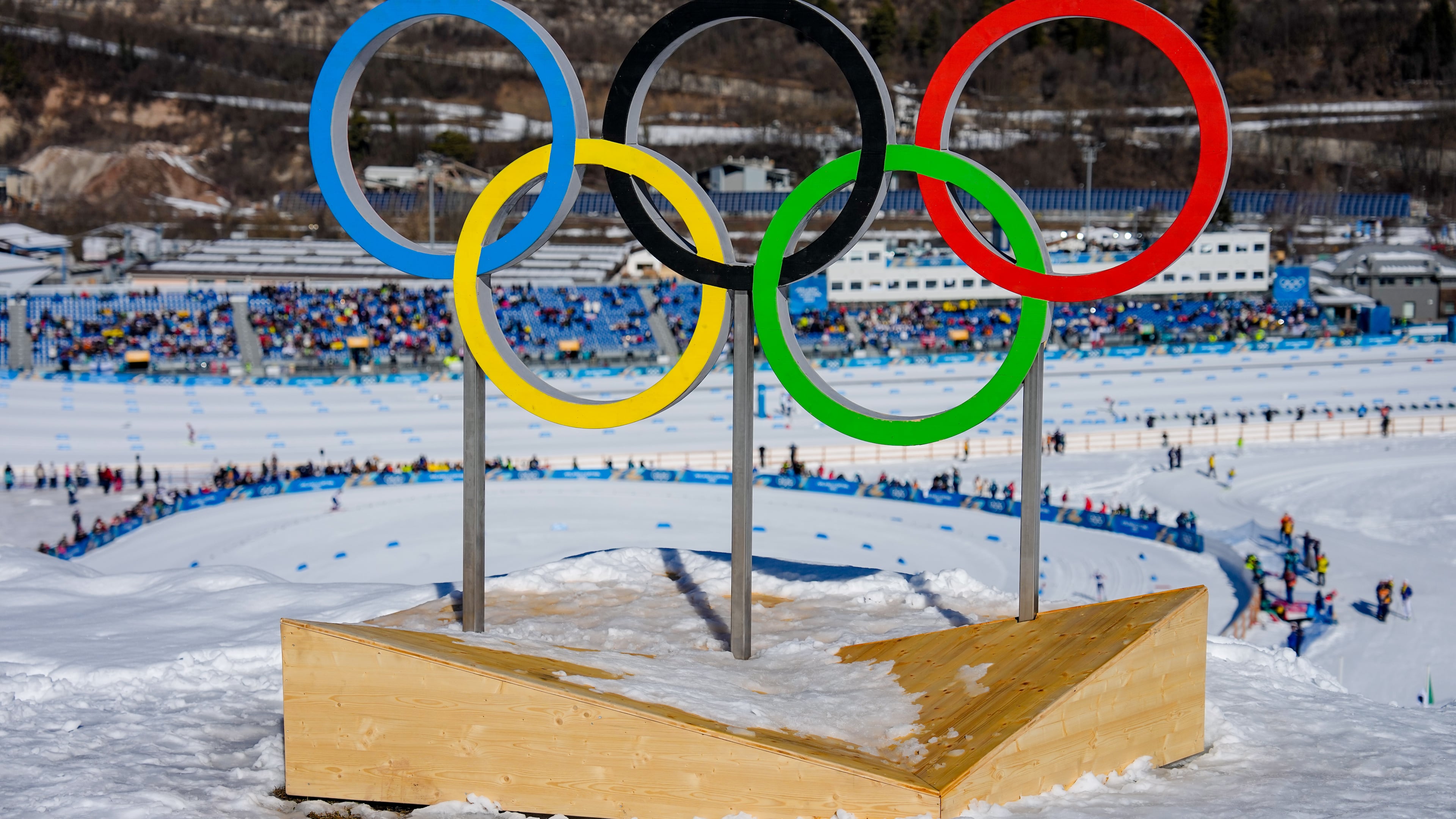 FILE - The Olympic rings stand above the course during the cross country skiing women's 50km mass start classic at the 2026 Winter Olympics, in Tesero, Italy, Feb. 22, 2026. (AP Photo/Matthias Schrader, File)