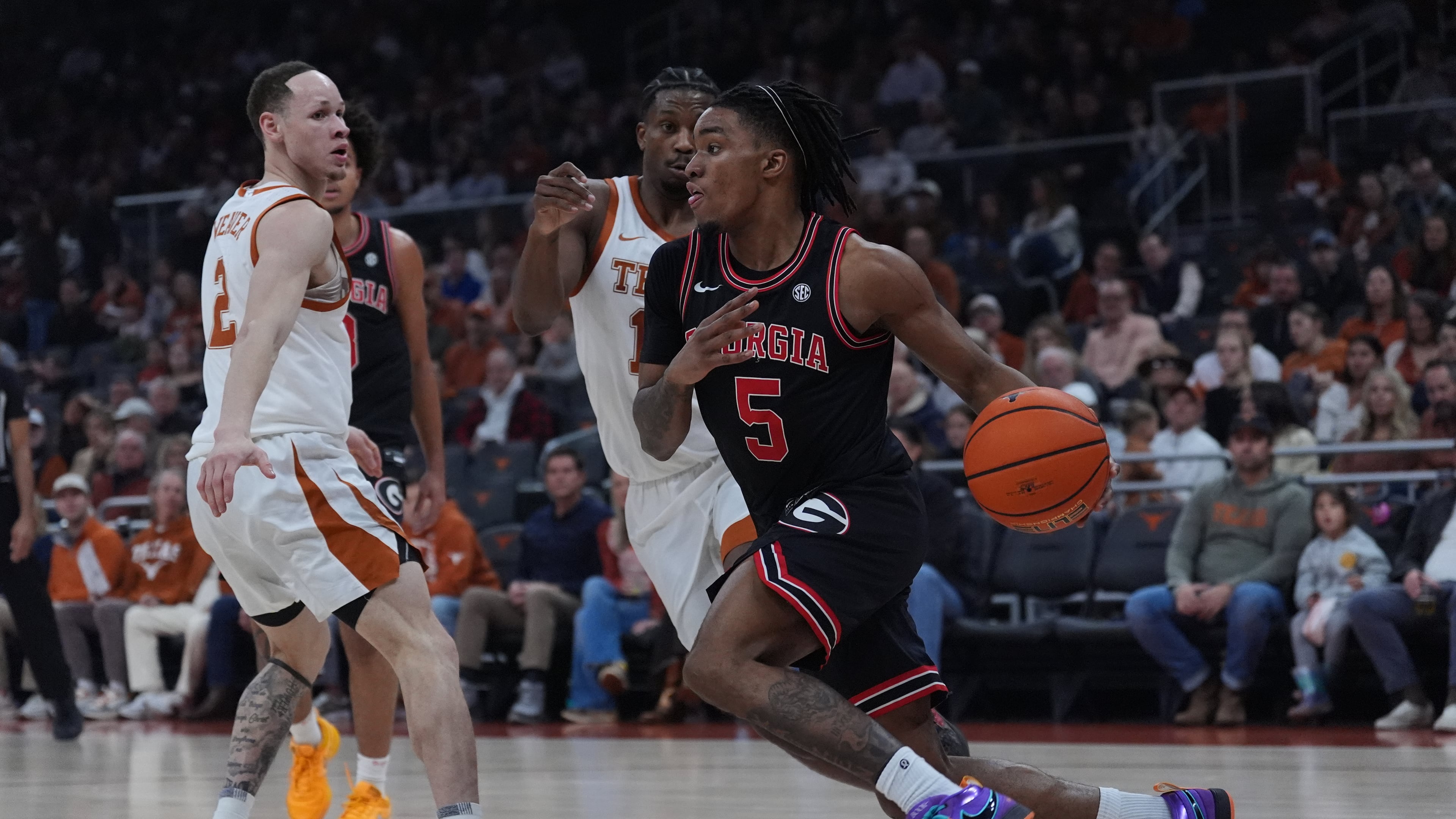 Georgia guard Jeremiah Wilkinson (right) drives around Texas guard Tramon Mark (center) during the first half Saturday, Jan. 24, 2026, in Austin, Texas. The Longhorns trailed 37-30 at halftime but beat the Bulldogs 87-67. (Eric Gay/AP)