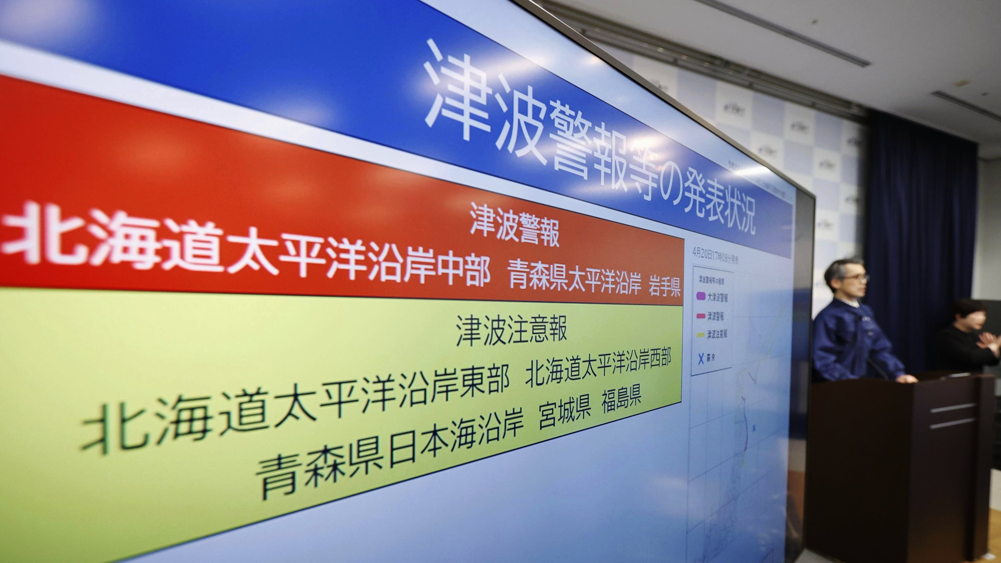 An official of the Japan Meteorological Agency speaks near a monitor showing a tsunami alert during a news conference at the agency in Tokyo, Monday, April 20, 2026, after an earthquake that struck off the northern Japanese coast. (Masanori Kumagai/Kyodo News via AP)