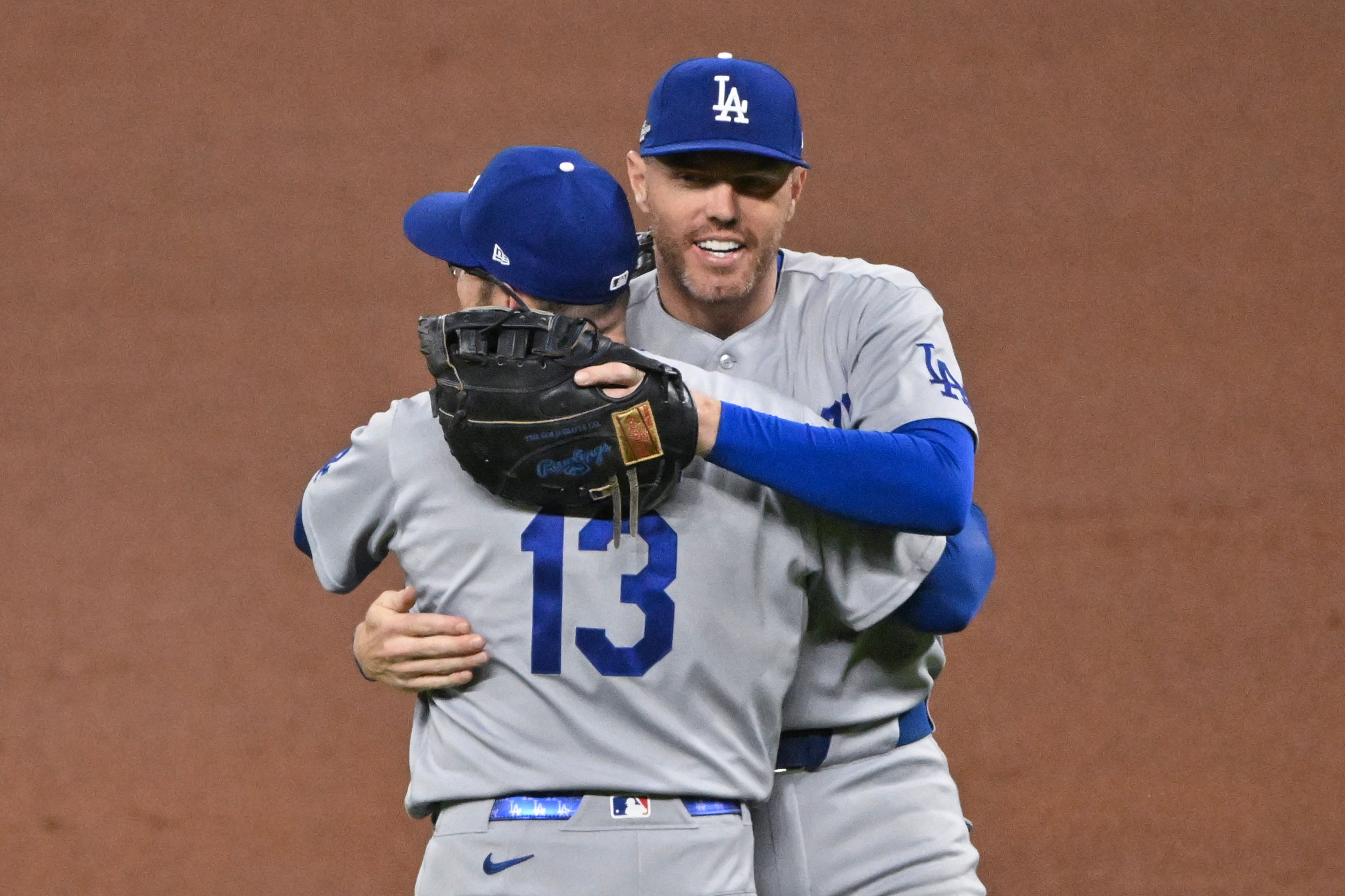 Los Angeles Dodgers first baseman Freddie Freeman, right, hugs third baseman Max Muncy (13) after defeating the Atlanta Braves in Game 4 of the MLB National League Division Series between the Atlanta Braves and the Los Angeles Dodgers, Wednesday, Oct. 7, 2026, in Atlanta. The Dodgers defeated the Braves 3 games to 1. (Hyosub Shin/AJC)