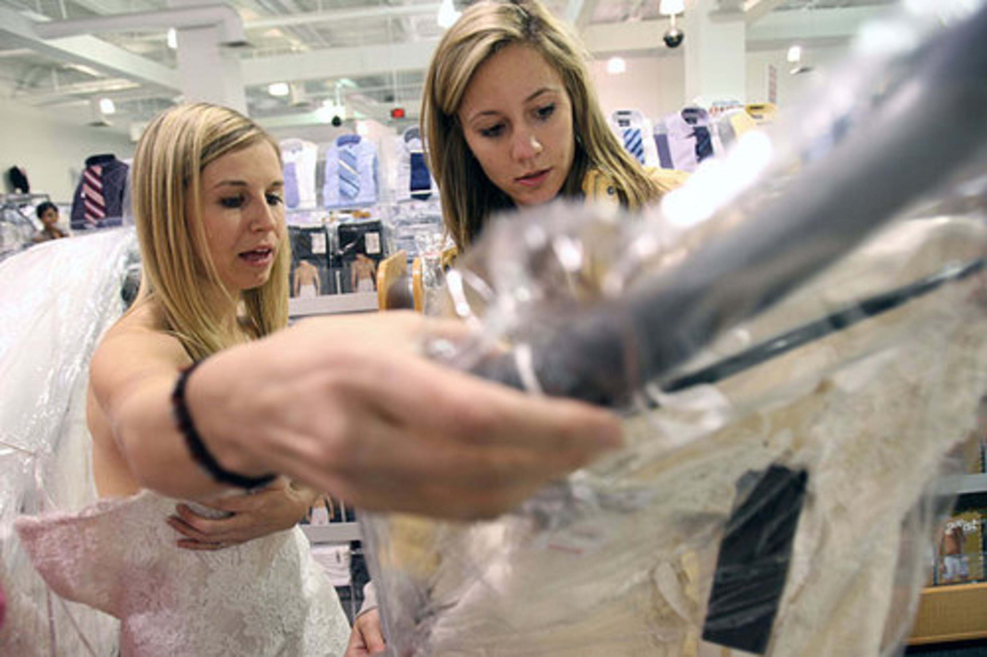 Joy Arnold, left, and Mireille Melton get to look for gowns half-hour before doors open because they won a local radio contest. Melton said she found her dress here at this event two years ago and Arnold found it for her. Arnold has a total of 11 helpers and all came from North Carolina. They camped out since 5 p.m. Thursday.