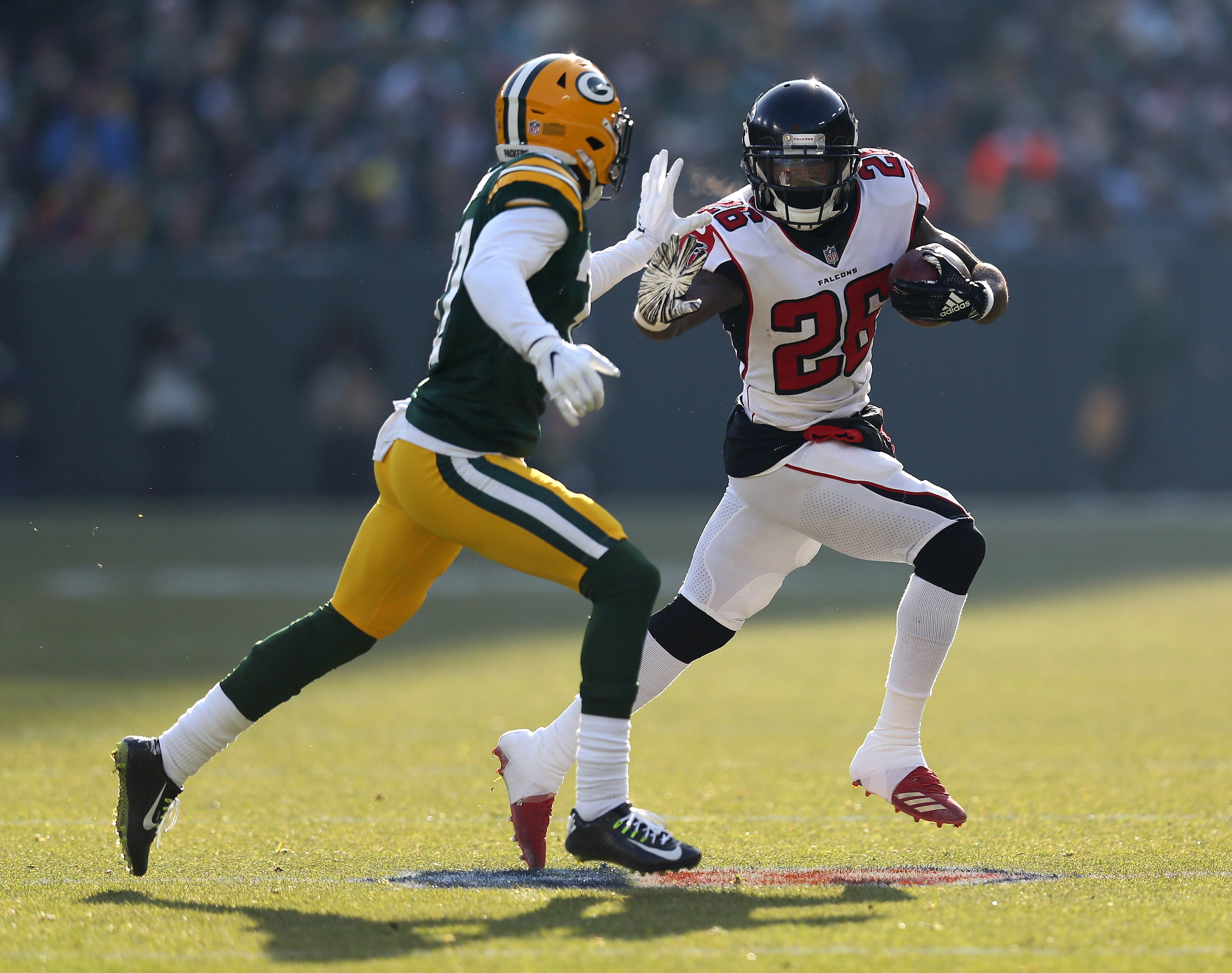 GREEN BAY, WISCONSIN - DECEMBER 09: Tevin Coleman #26 of the Atlanta Falcons runs against Josh Jackson #37 of the Green Bay Packers during the first half of a game at Lambeau Field on December 09, 2018 in Green Bay, Wisconsin. (Photo by Dylan Buell/Getty Images)