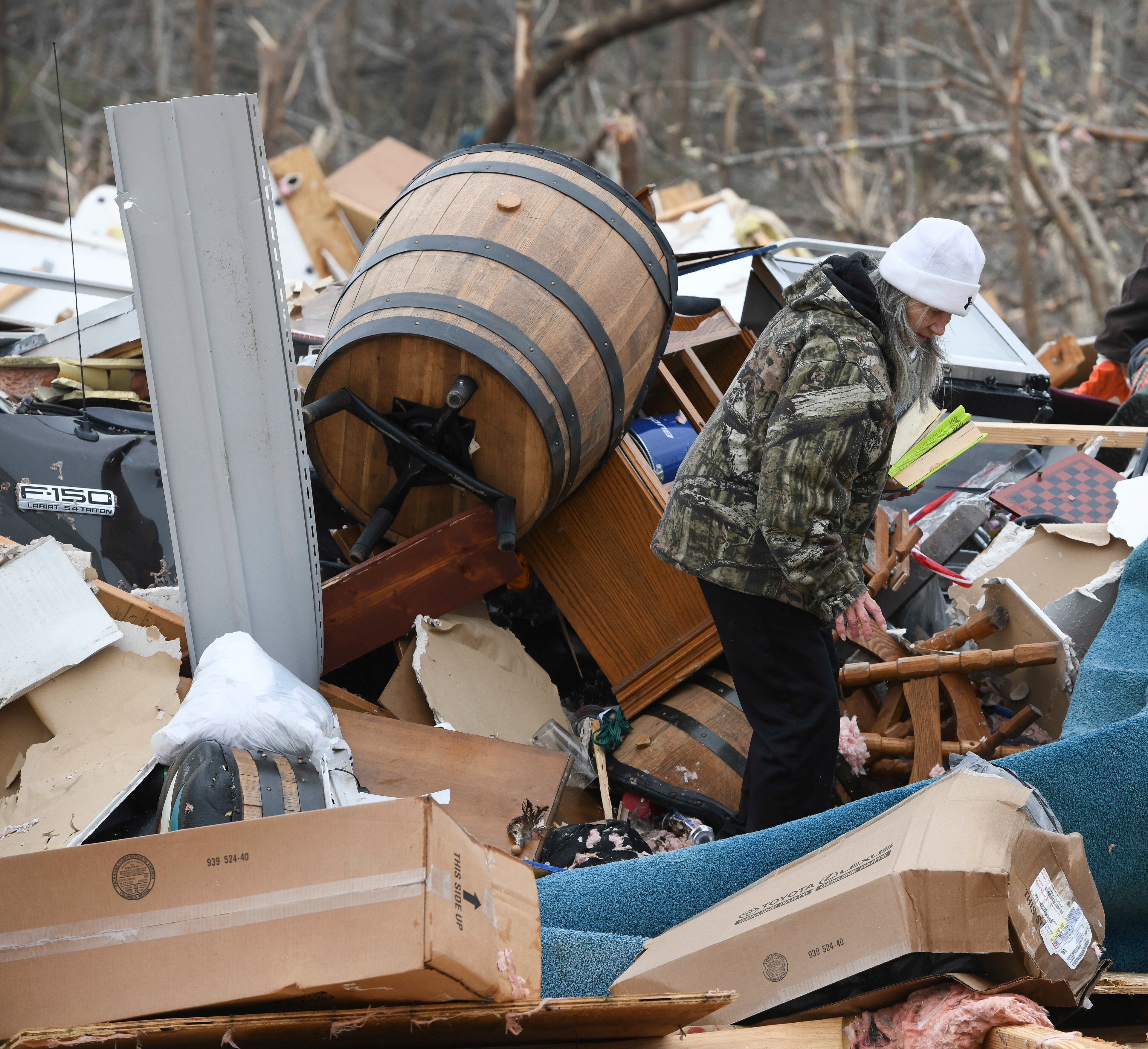 Julie Morrison looks through the debris of her destroyed home on Lee County Road 63 in Beauregard, Ala., Monday, March 4, 2019, the day after a deadly tornado ravaged the area, in Beauregard, Ala., Monday, March 4, 2019. (AP Photo/Julie Bennett)