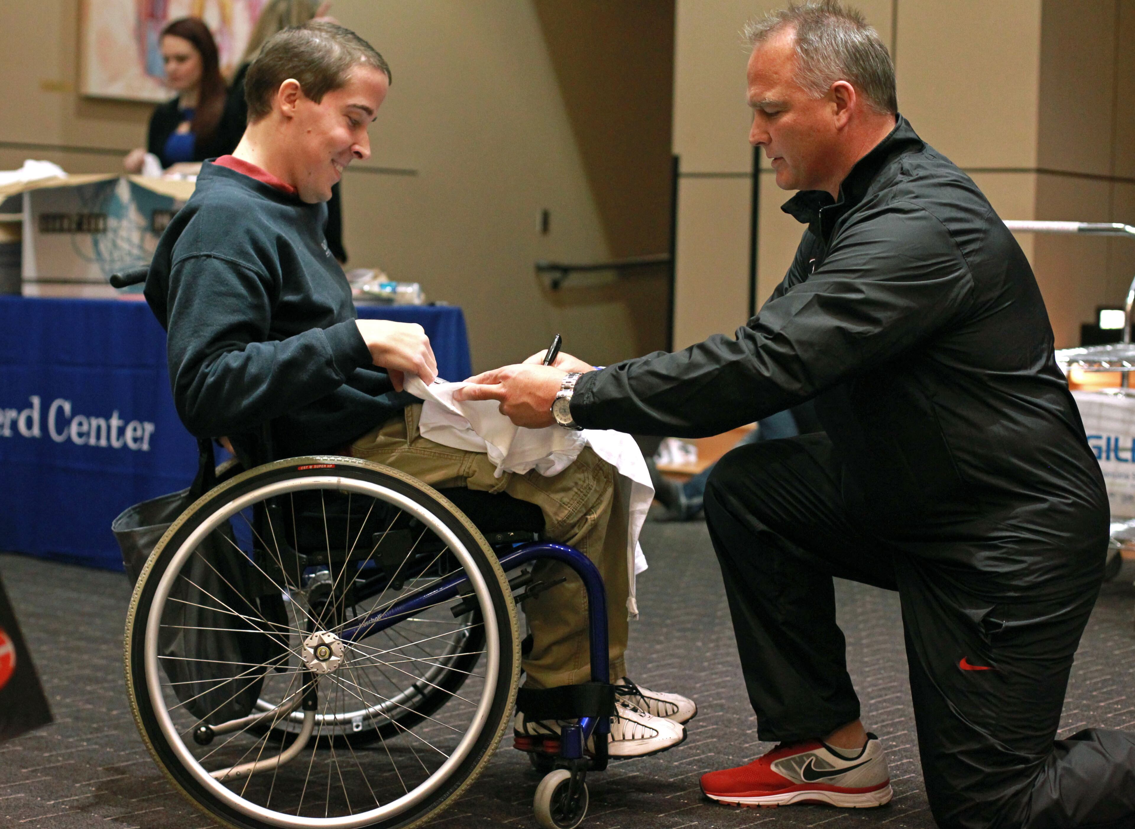 University of Georgia coach Mark Richt, right, gives an autograph to Troy Compher, of Ashburn, Virginia, as other members of the University of Georgia football team visit patients at the Shepherd Center the day before the Bulldogs' regular season finale at Georgia Tech Friday afternoon in Atlanta, Ga., November 29, 2013. The Georgia football team split into two groups one visiting the Shepherd Center and the other visiting Children's Healthcare of Atlanta. The visits have become a tradition for the Bulldog team every other year when playing at Georgia Tech on Thanksgiving weekend.