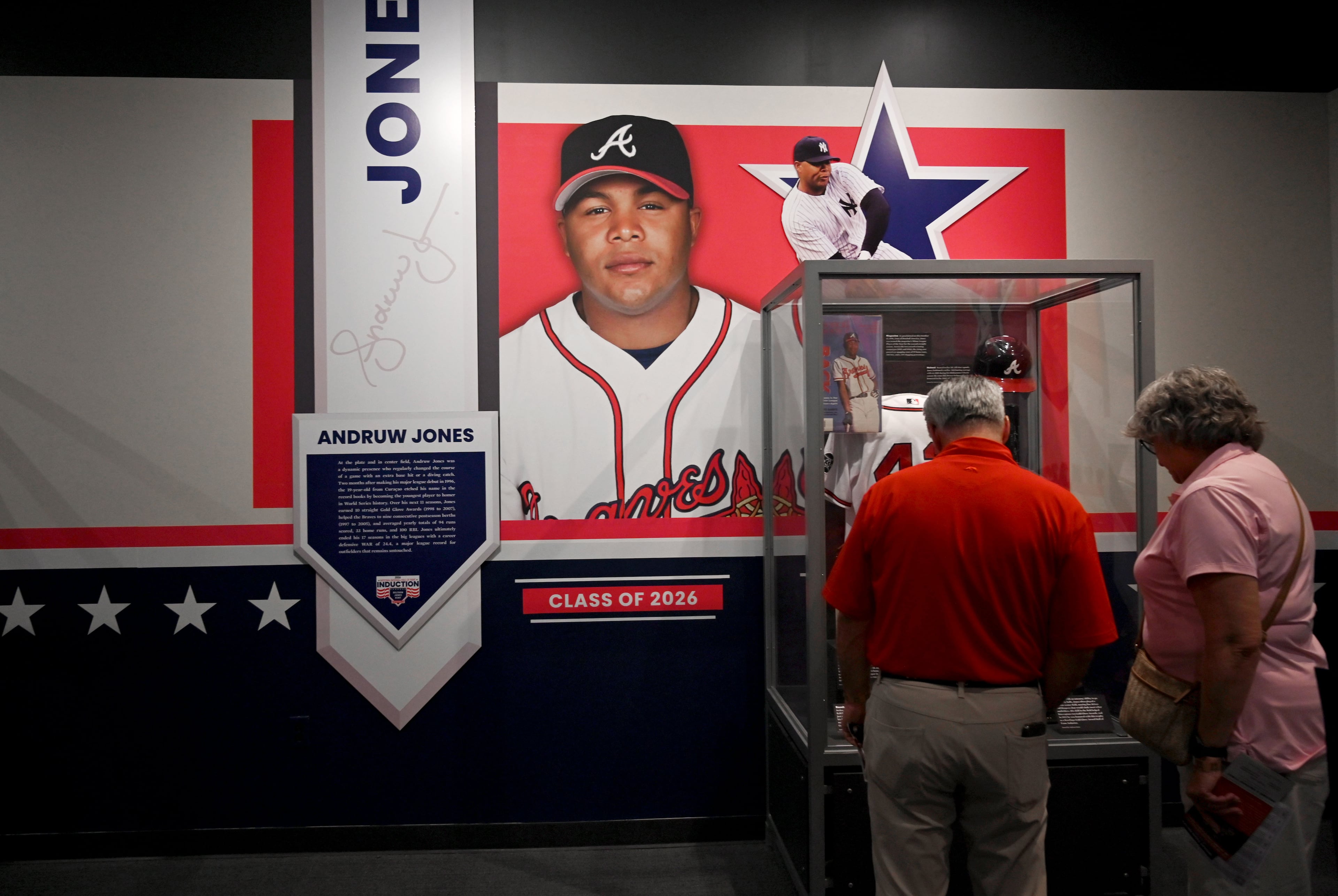 Baseball fans check out displays featuring former Atlanta Braves center fielder Andruw Jones at the National Baseball Hall of Fame and Museum on Friday, July 24, 2026, in Cooperstown, N.Y. Andruw Jones will be inducted into the National Baseball Hall of Fame on Sunday as part of the Class of 2026, alongside Carlos Beltrán and Jeff Kent. He is recognized as one of the greatest center fielders in baseball history. Jones will become the 12th player with ties to the Atlanta Braves to be inducted into the Hall of Fame. (Hyosub Shin/AJC)