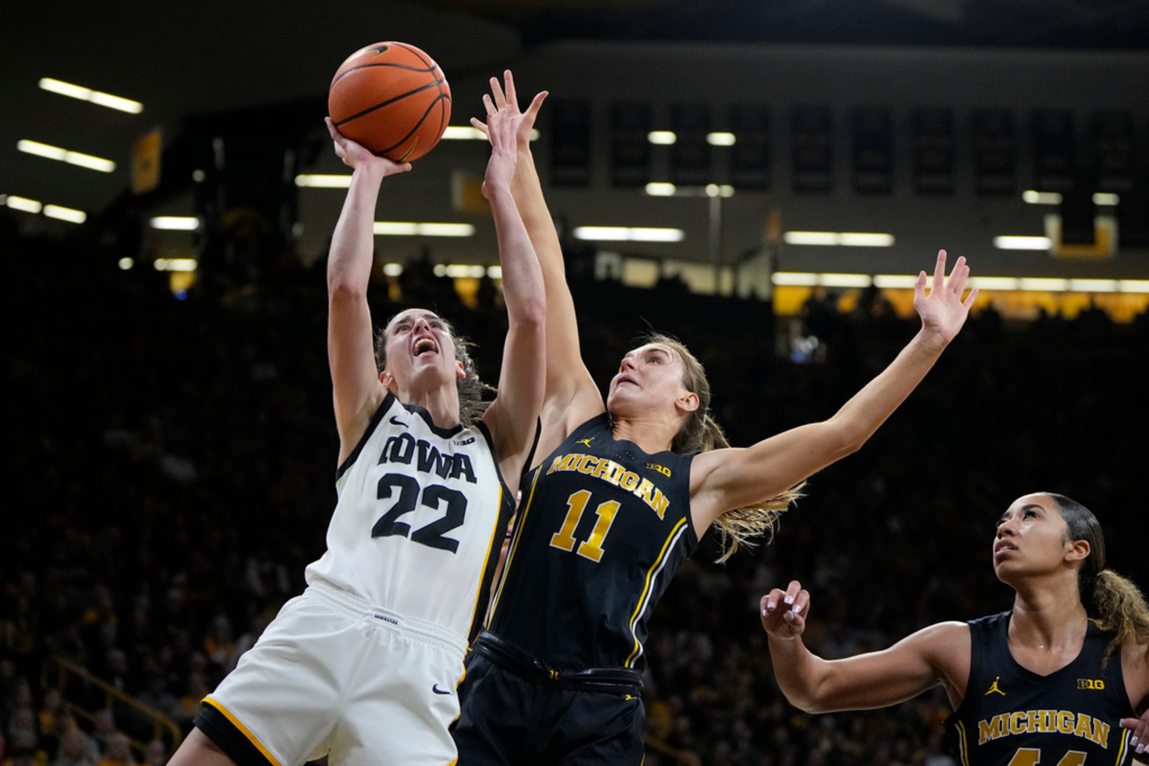 Iowa guard Caitlin Clark (22) pulls up for a shot as Michigan guard Greta Kampschroeder (11) defends during the second half of an NCAA college basketball game Thursday, Feb. 15, 2024, in Iowa City, Iowa. (AP Photo/Matthew Putney)