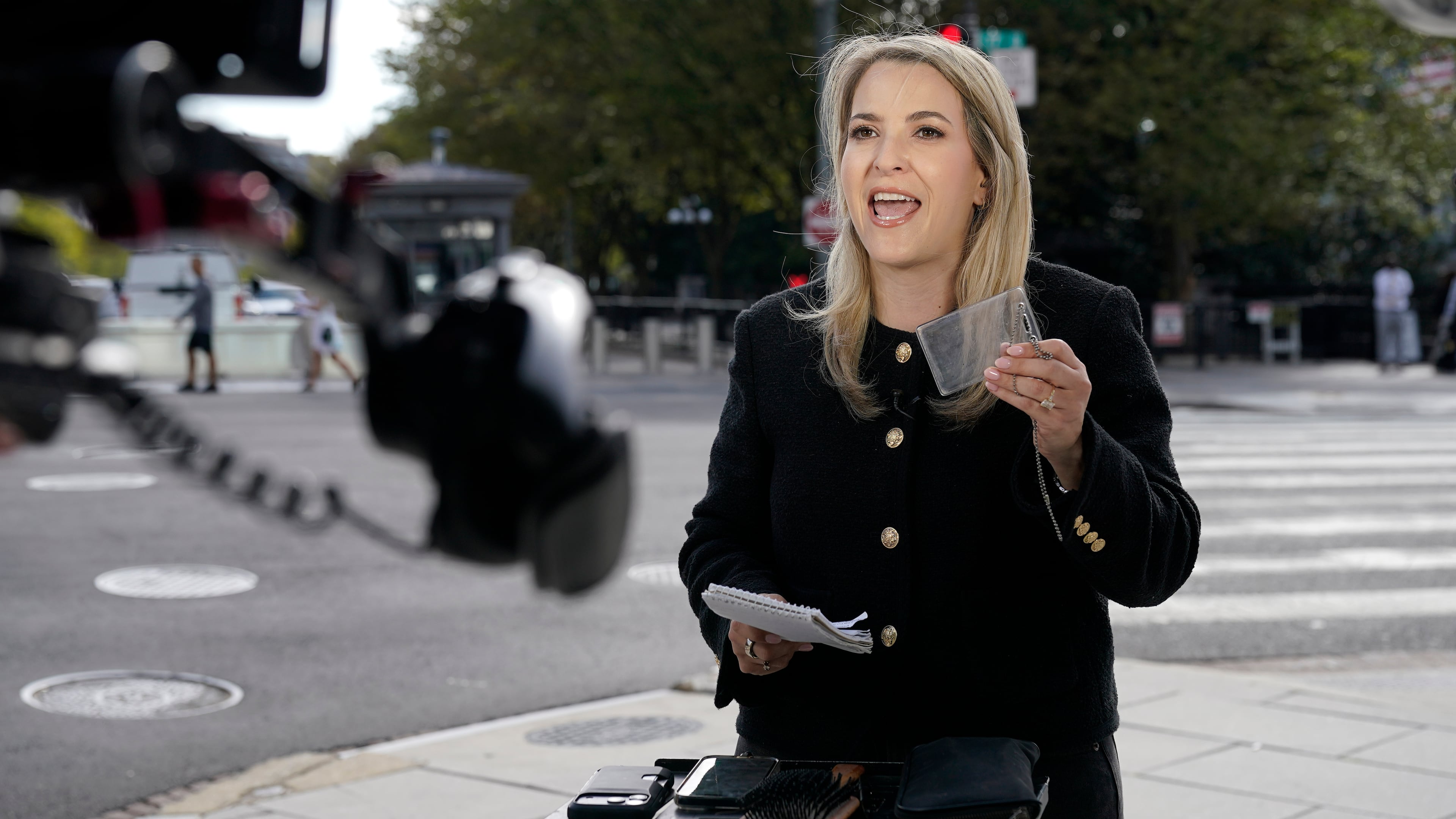 CNN Senior White House Reporter Betsy Klein, holding up an empty credential holder, reports near the White House complex after having her credential confiscated following President Donald Trump's ban on CNN, MS NOW and Politico, Saturday, Sept. 19, 2026, in Washington. (Jose Luis Magana/AP)