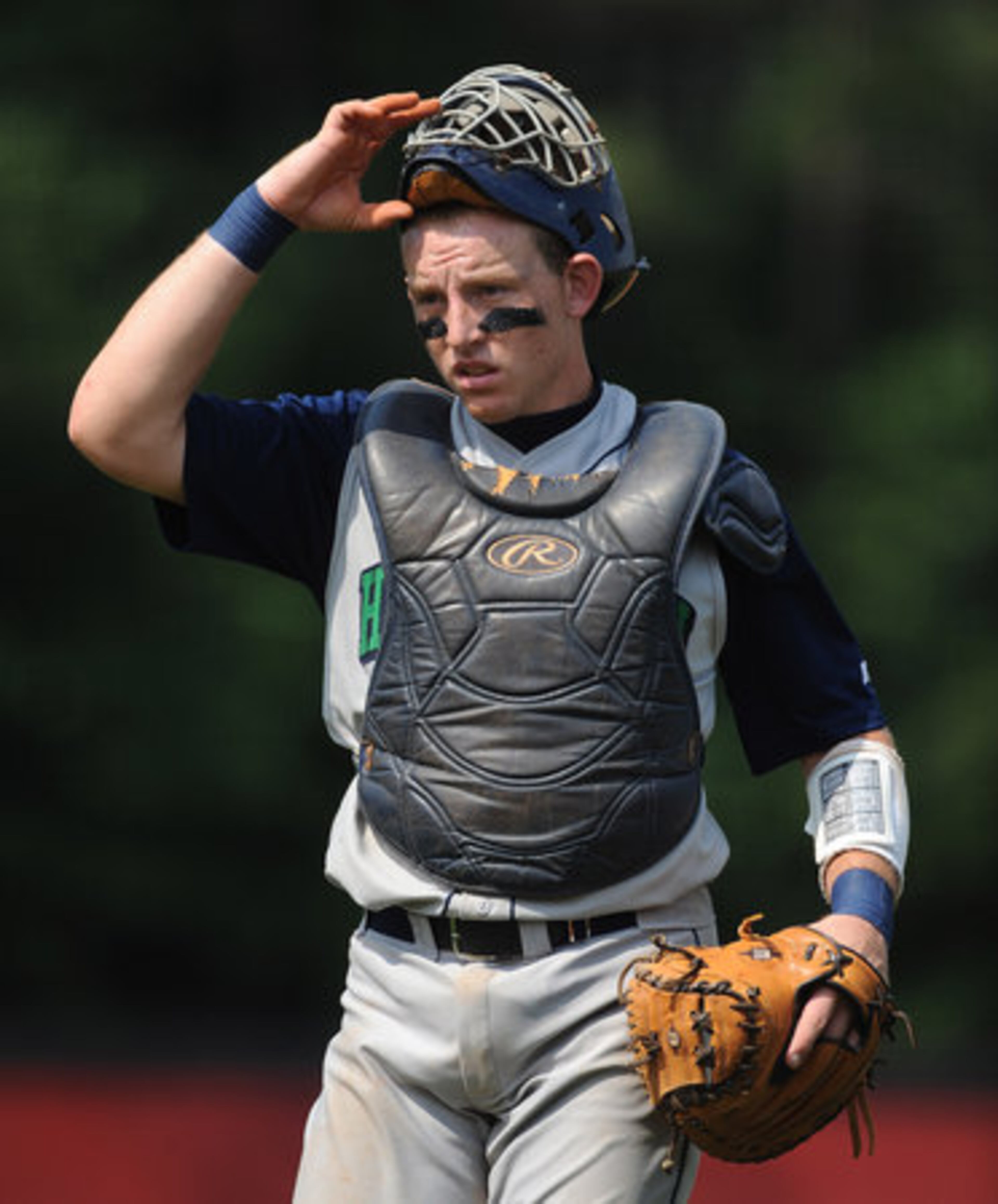 Harrison High School's catcher Adam Martin pulls down his mask.