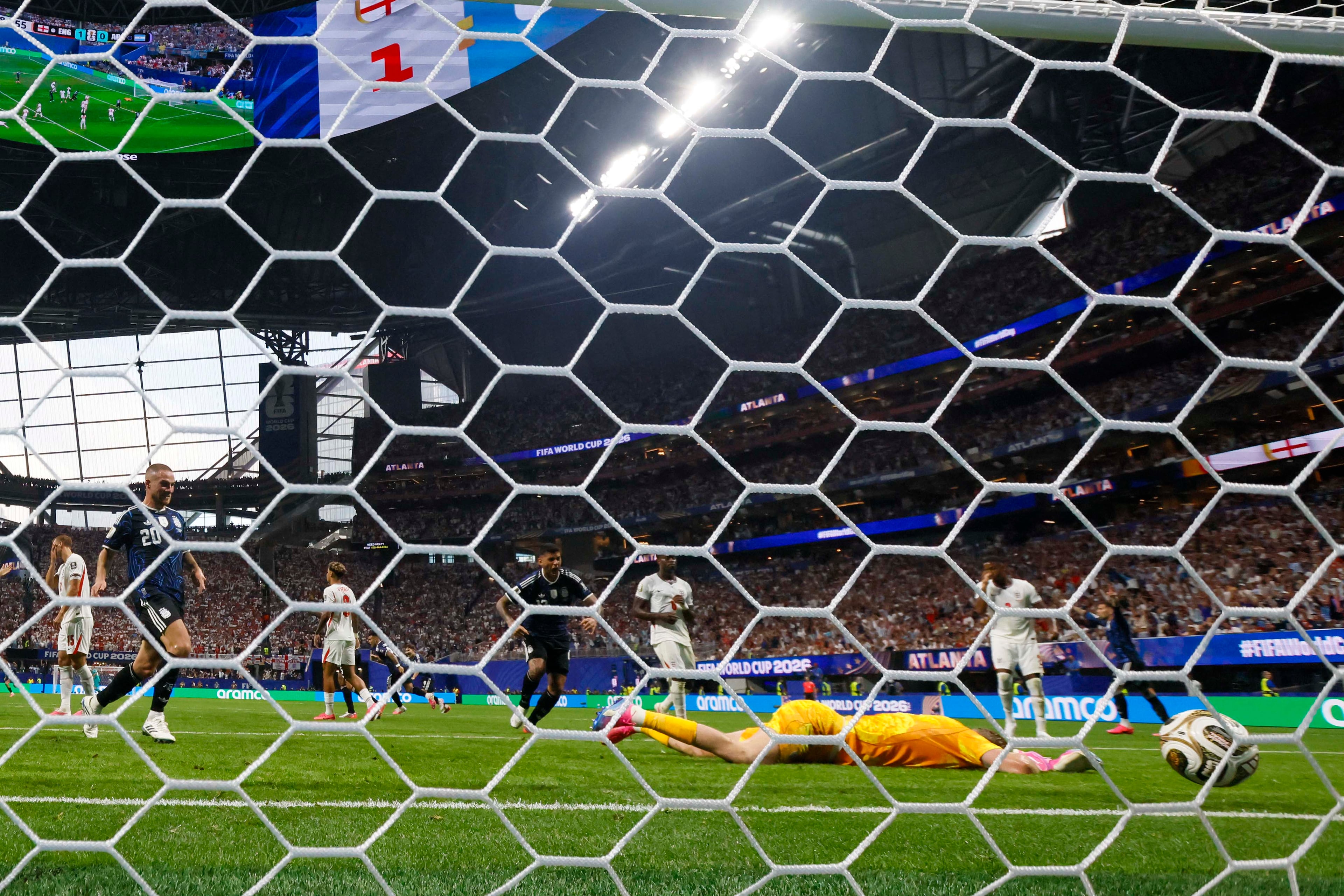 England goalkeeper Jordan Pickford (1) lies on the ground after Argentina midfielder Enzo Fernández (24) scored during the World Cup semifinal soccer game between Argentina and England at Mercedes-Benz Stadium in Atlanta on Wednesday, July 15, 2026. (Miguel Martinez/AJC)