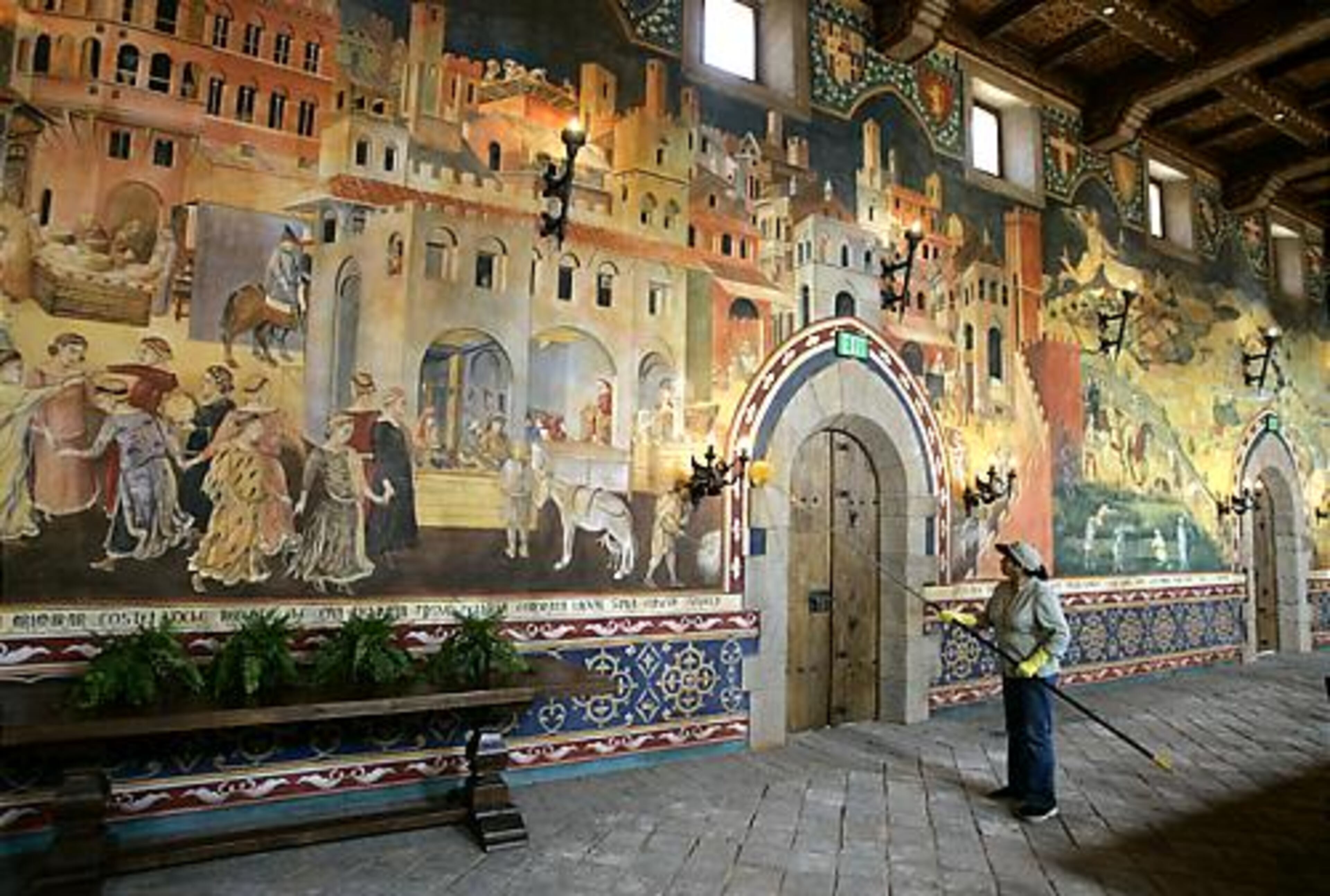 A worker cleans a wall inside the Great Hall, which is 72 feet long and 22 feet high and decorated with huge frescoes replicas of medieval Italian paintings that took two Italian artists about a year and a half to complete.