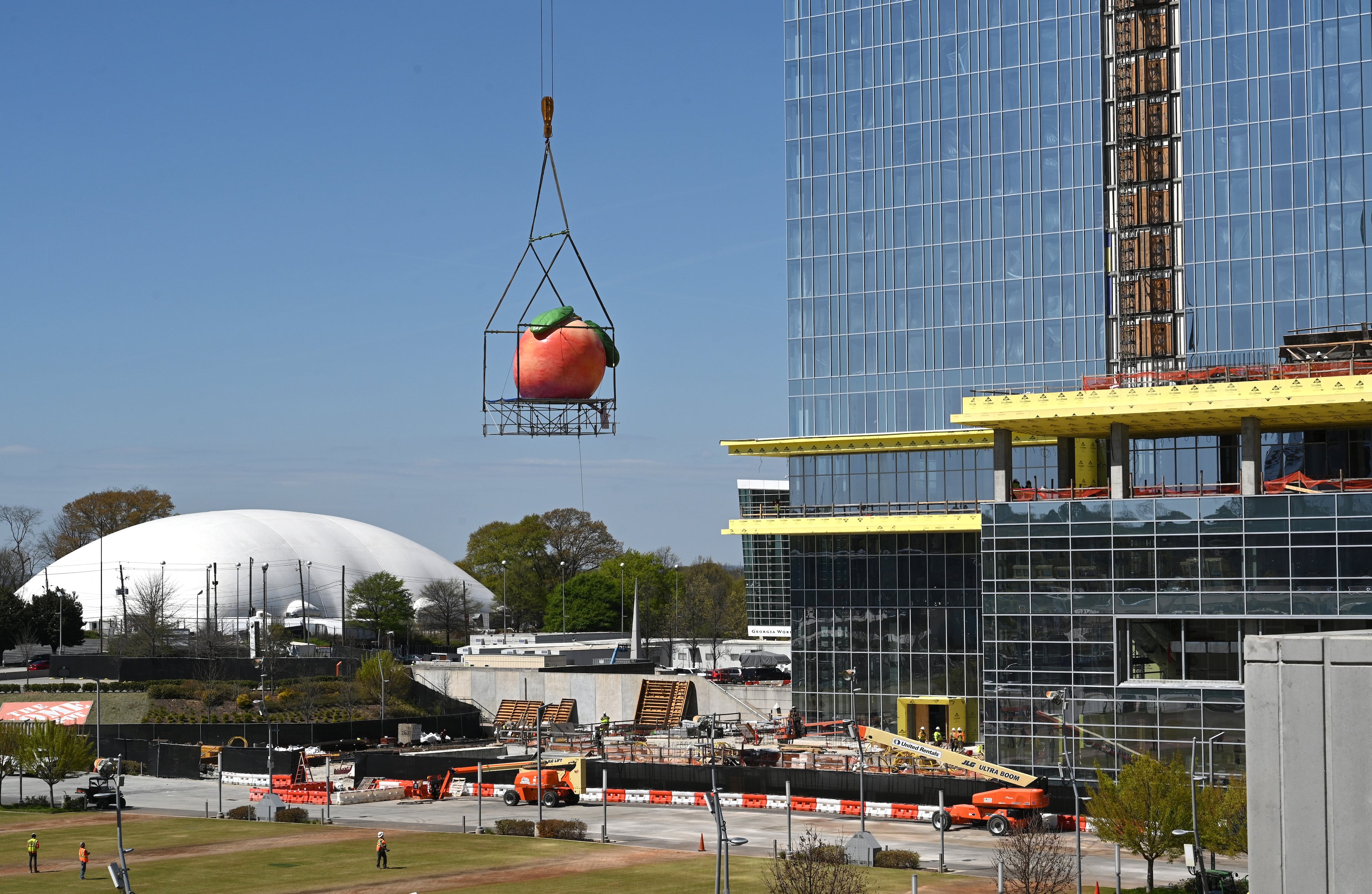 Construction crews placed a giant peach near the top of the Signia by Hilton Atlanta hotel on Thursday, March 23, 2023, ahead of a topping-out ceremony scheduled for the following week.