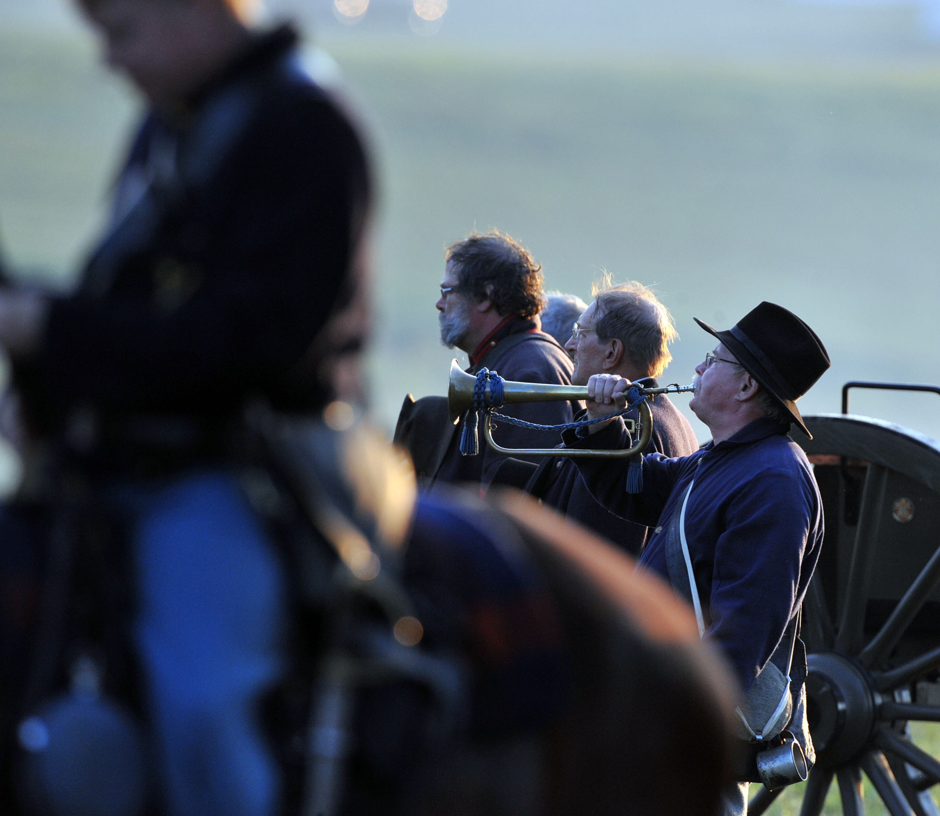 The bugler, previously busy relaying battle calls, plays Taps at the end of the battle reenactment. Bugle calls and signal flags were used to relay critical information to troops and commanders. Confederate and Union reenactors recreate the Battle of Utoy Creek during the Atlanta Campaign's Battle of Atlanta re-enactment at the Nash Farm Battlefield Friday, September 19, 2014. Thousands of re-enactors and spectators are expected to descend on Nash Farm Battlefield for this weekend's Battle of Atlanta events starting Friday and ending Sunday afternoon. Kilpatrick's Raid, the Battle of Cheatham's Hill, and Battle of Atlanta will be reenacted Saturday and Sunday. Confederate and Federal troops are in separate encampments about a 1/2 mile apart at the site. KENT D. JOHNSON / KDJOHNSON@AJC.COM