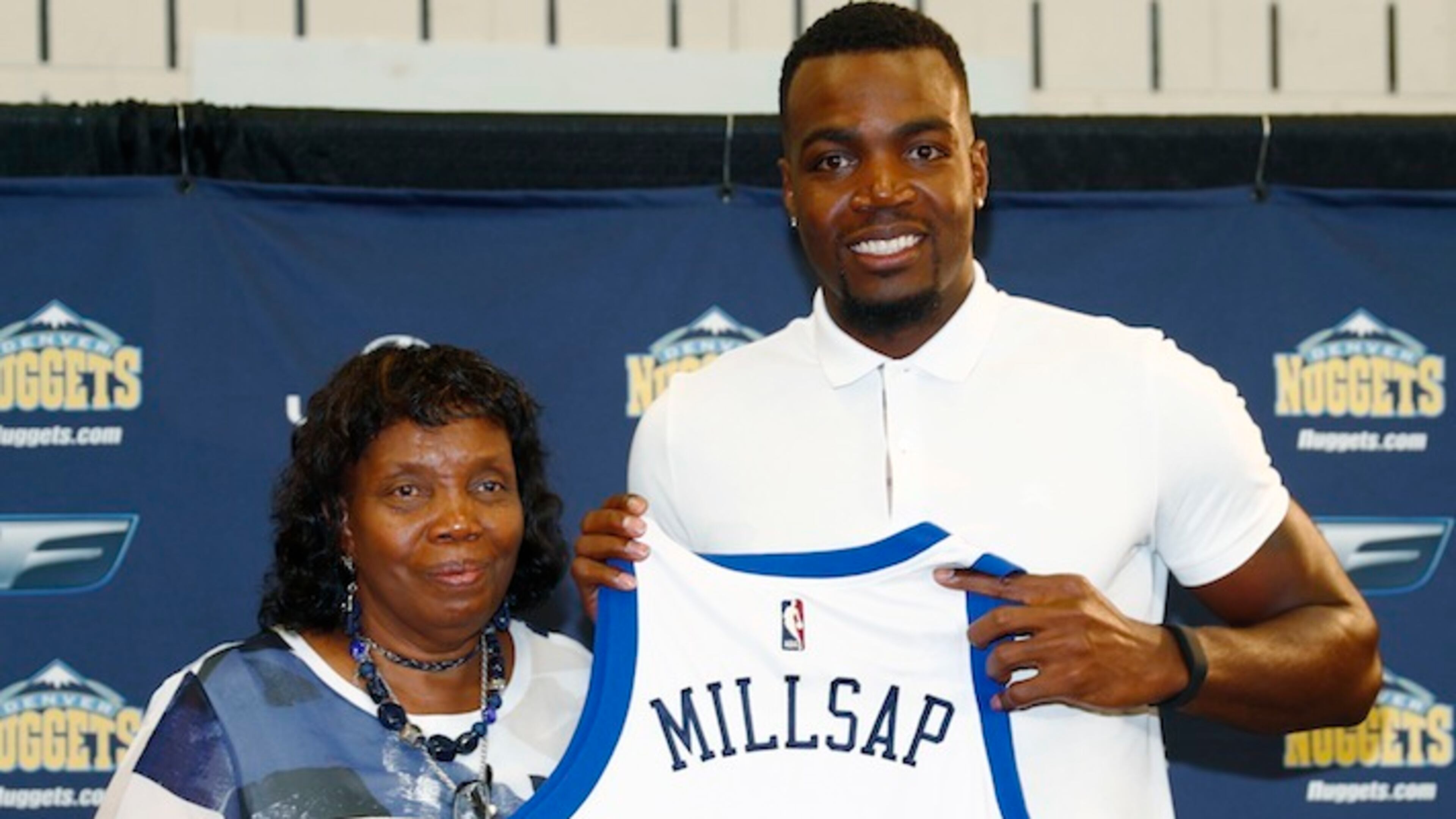 Denver Nuggets new forward Paul Millsap, right, holds up his jersey with his mother, Bettye, during the player's introduction to the media at a news conference Thursday, July 13, 2017, in Denver. (AP Photo/David Zalubowski)