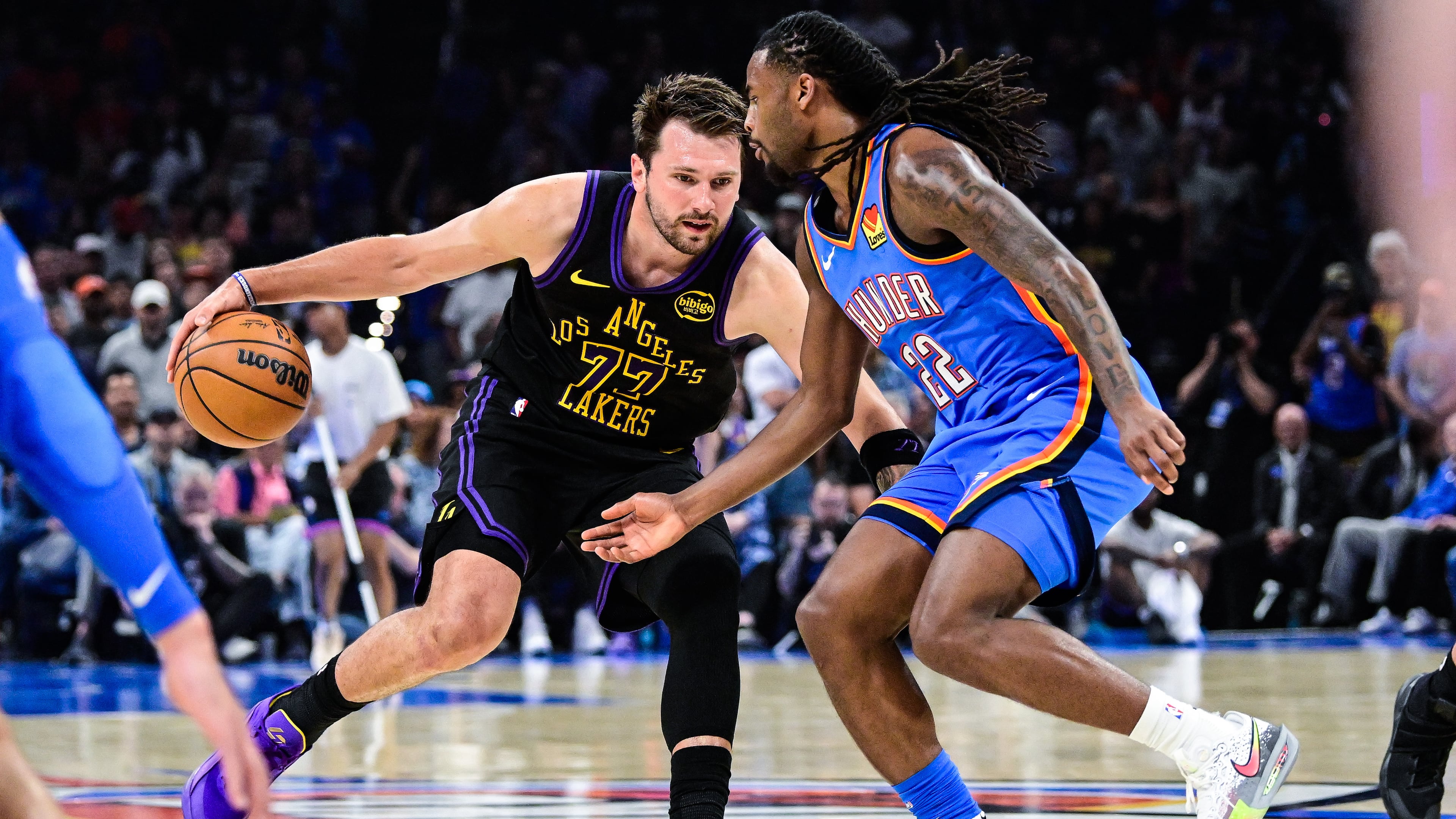 Los Angeles Lakers forward/guard Luka Dončić (77) drives against Oklahoma City Thunder guard Cason Wallace (22) during the first half of an NBA basketball game Thursday, April. 2, 2026, in Oklahoma City. (AP Photo/Gerald Leong)