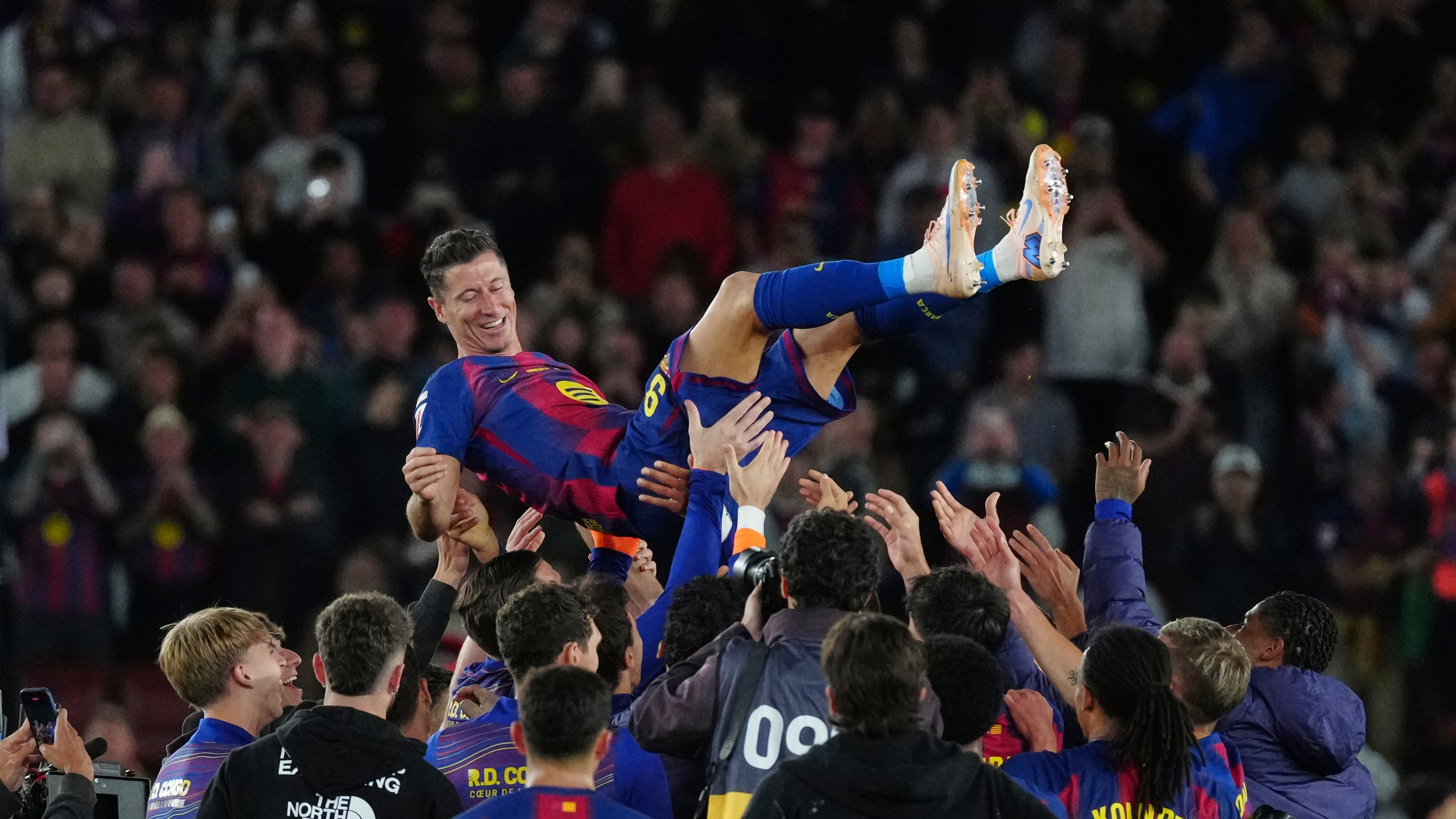 Barcelona's Robert Lewandowski is thrown into the air by his teammates after his last game for the club at the end of the Spanish La Liga soccer match between FC Barcelona and Real Betis in Barcelona, Spain, Sunday, May 17, 2026. (AP Photo/Joan Mateu Parra)