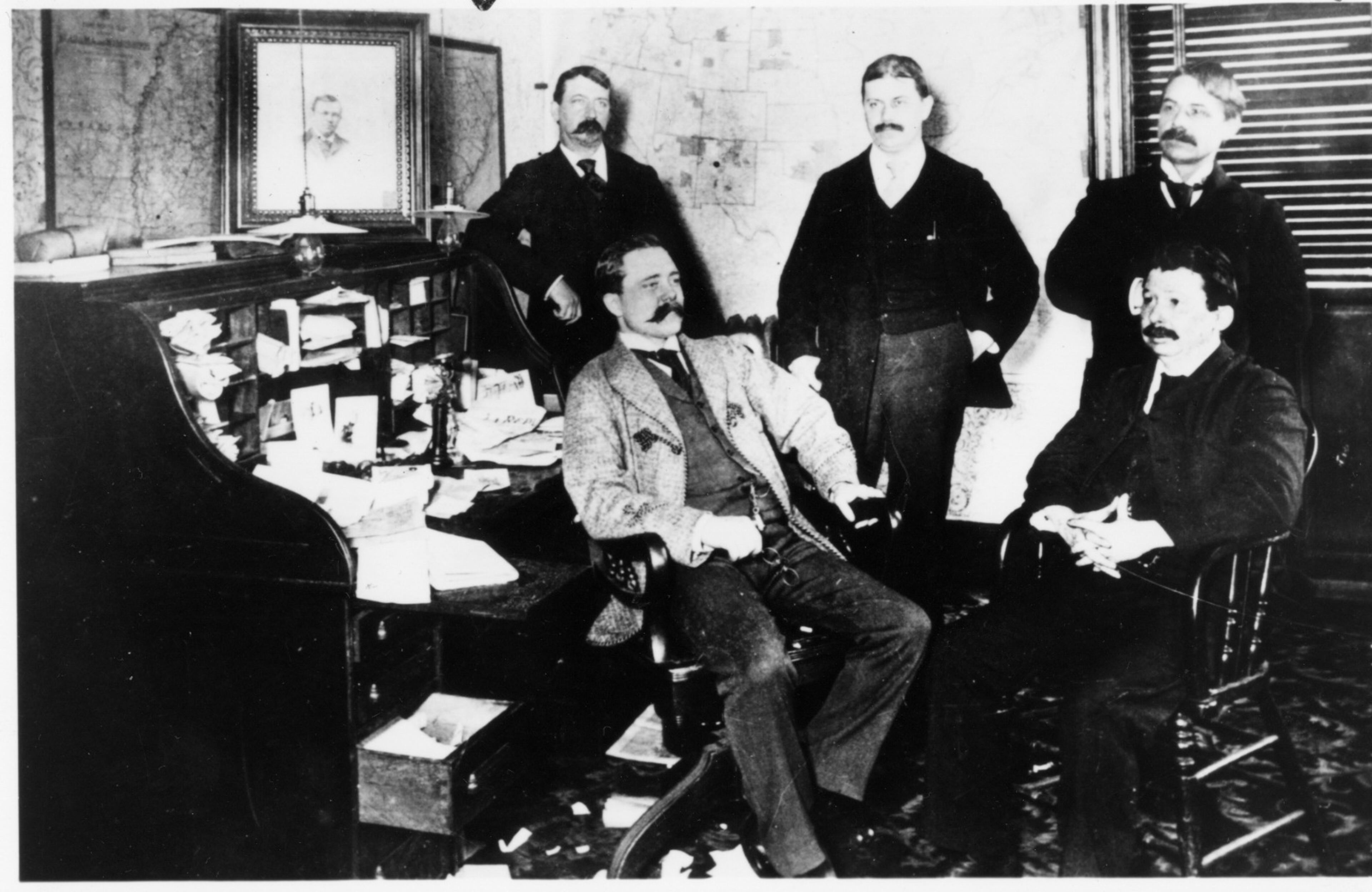 Constitution editors gather after the death of Henry Grady in 1889. From left, they are (standing) editorial writer Wallace P. Reed, city editor J.K. Ohl, columnist Frank L. Stanton, (seated) new managing editor Clark Howell and chief editorial writer Joel Chandler Harris.