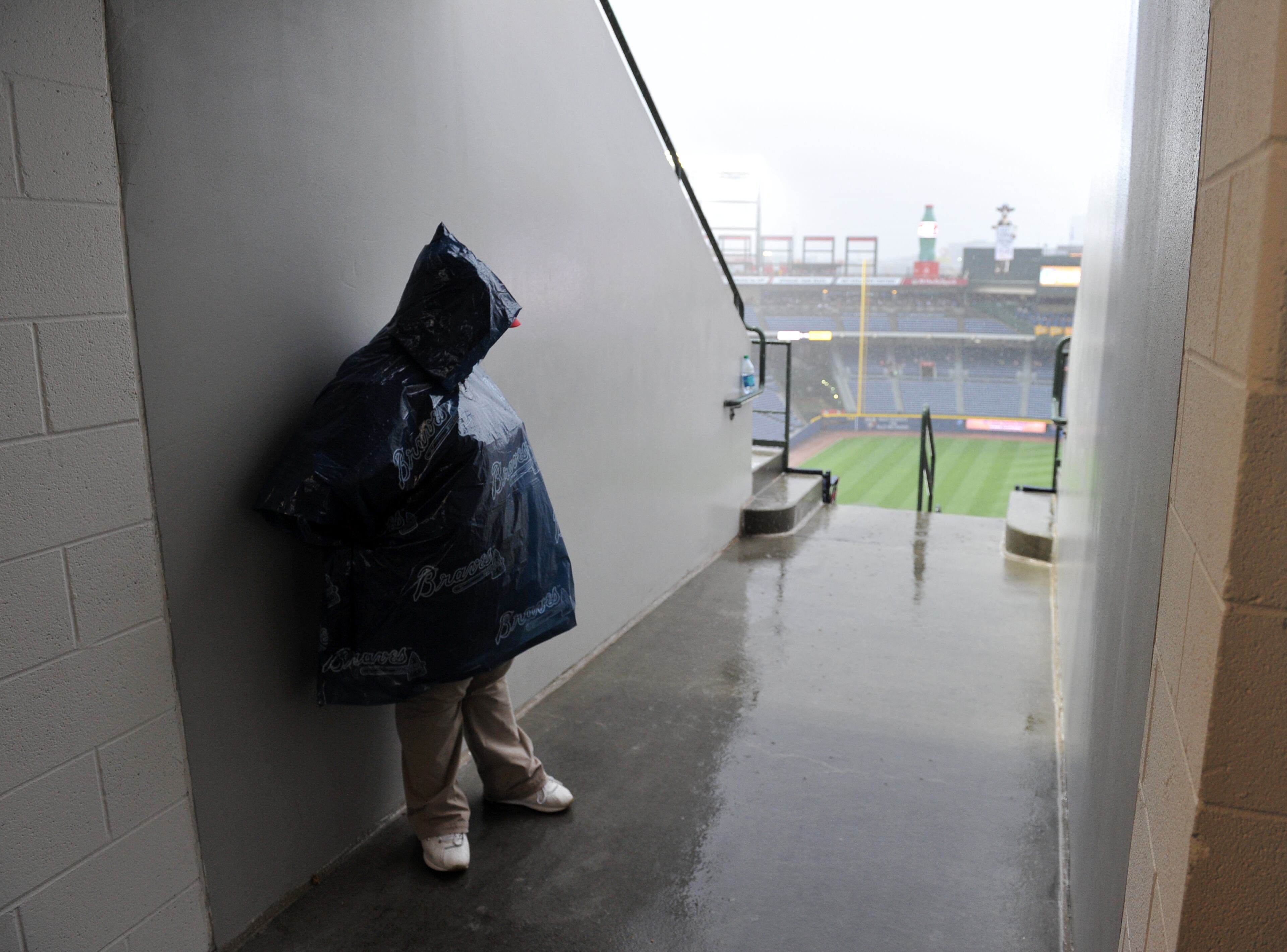 A usher waits out the rain before the start of the Atlanta Braves game at Turner Field Friday May 9, 2014. The Braves are scheduled to play the Chicago Cubs tonight at 7:35pm. BRANT SANDERLIN /BSANDERLIN@AJC.COM
