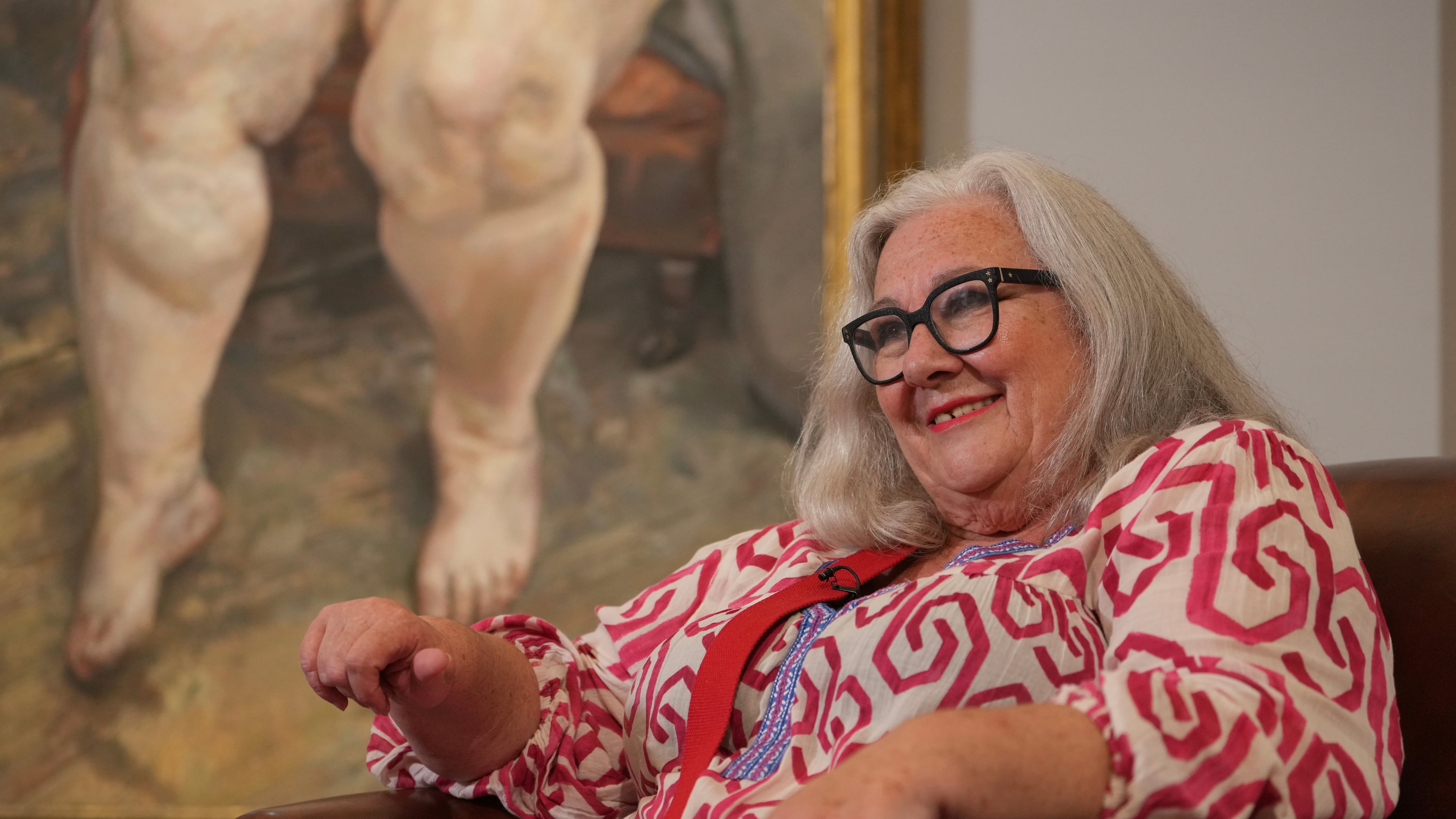 Sue Tilley, a model for British painter Lucian Freud, speaks in front of Freud's painting of her, titled "Sleeping by the Lion Carpet" during an interview in Sotheby's auction house in London, Thursday, May 28, 2026. (AP Photo/Kin Cheung)