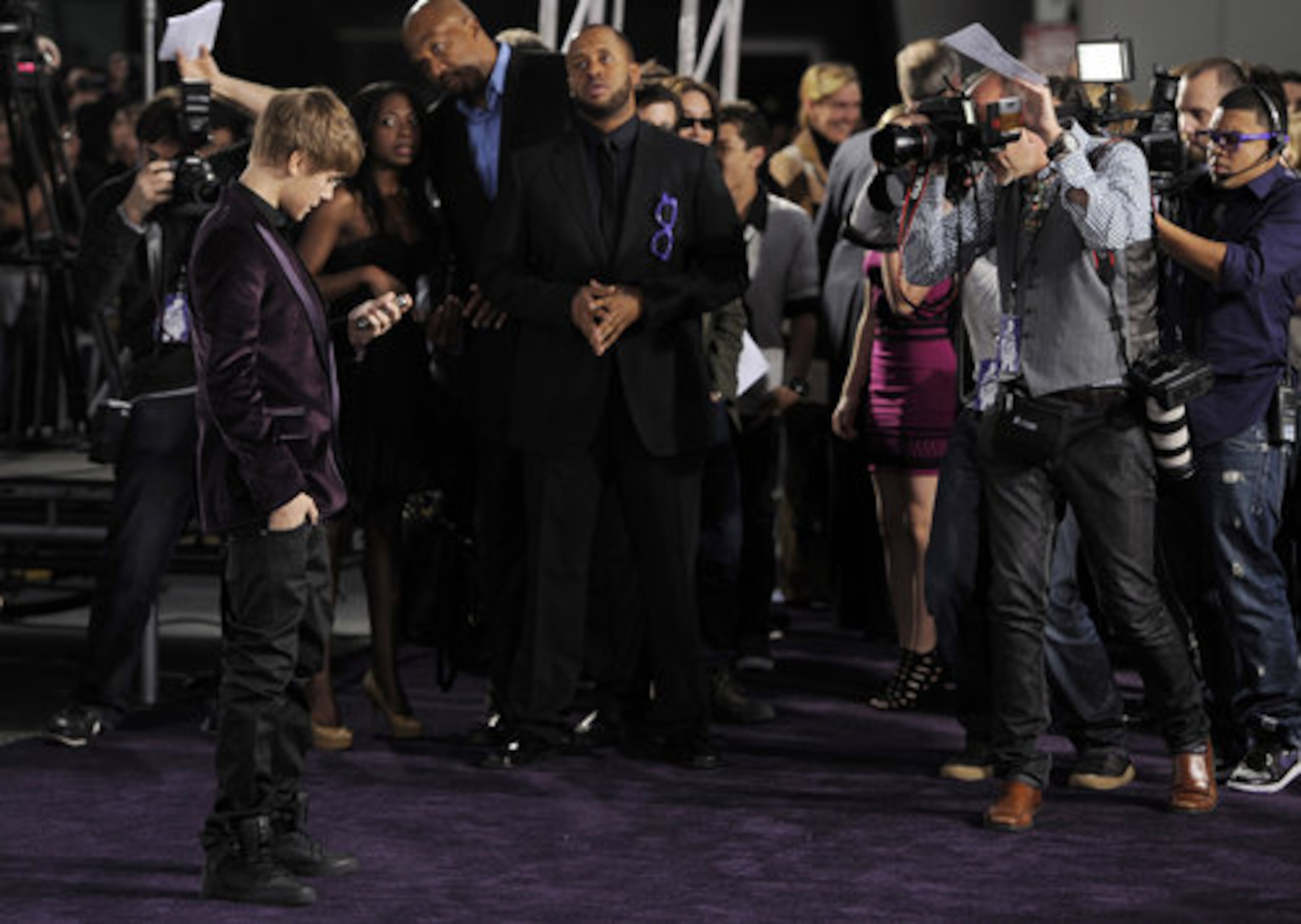 Really, Justin Bieber, who's on the phone, President Obama? Bieber stops to check his phone at the premiere for his own movie.