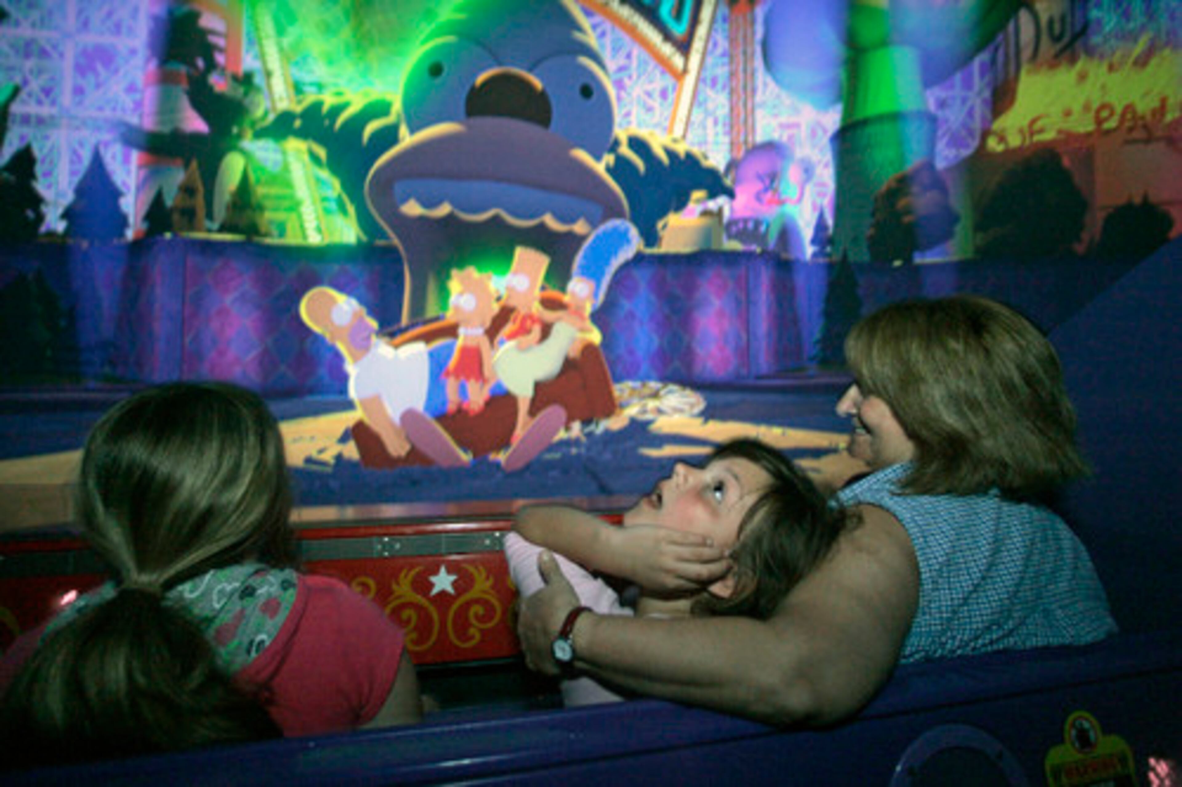 Dorothy Hughes, of Seattle, takes a spin on the Simpsons ride with granddaughters, Makensie, 7, center, and Alexis, 11, left.