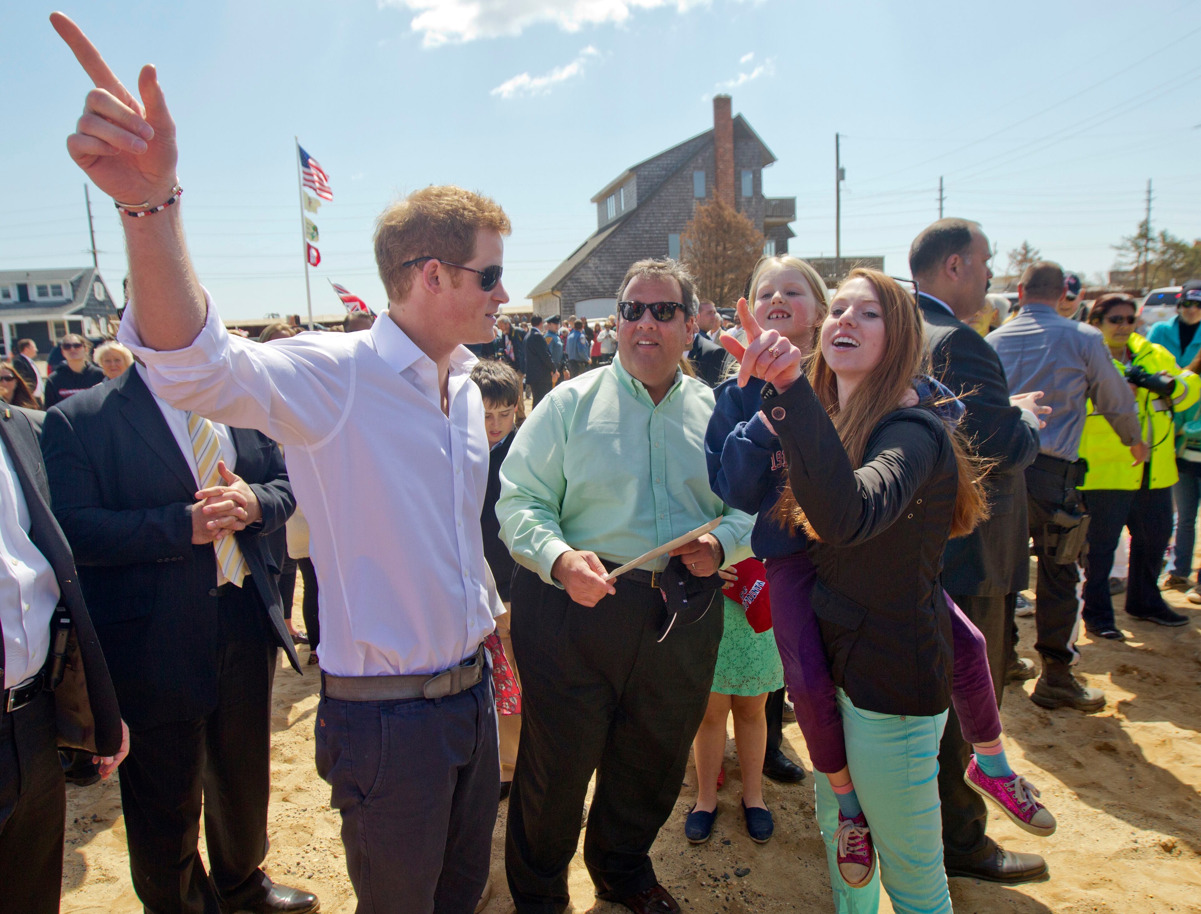 Britain's Prince Harry and N..J. Gov. Chris Christie talk with members of the the Bowden family on their empty lot in Mantoloking, N.J.
