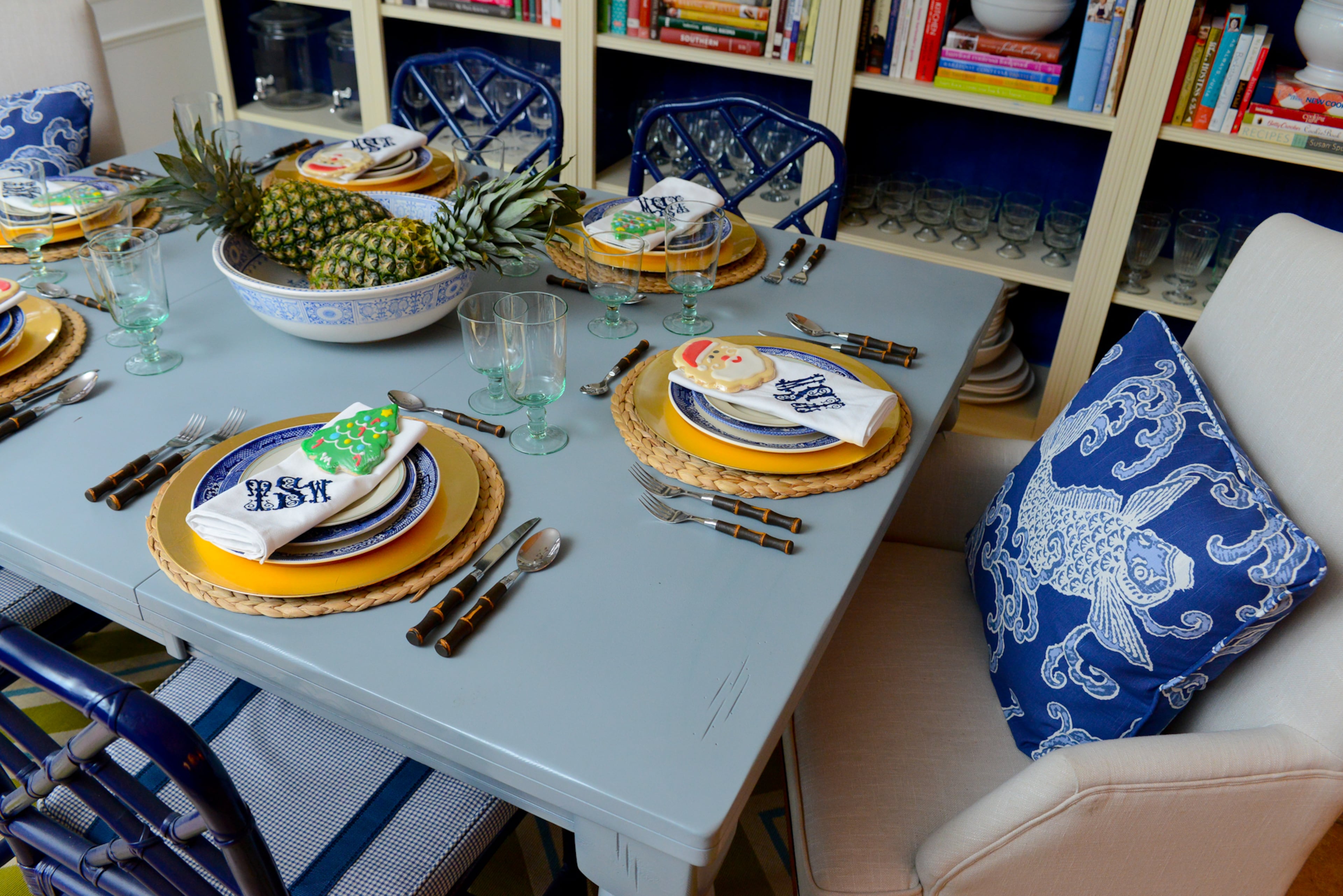 Gold chargers from Wayfair.com showcase vintage blue china that Travis Snyder has collected over time. Custom chair cushions and pillows tie in with the tabletop pieces.