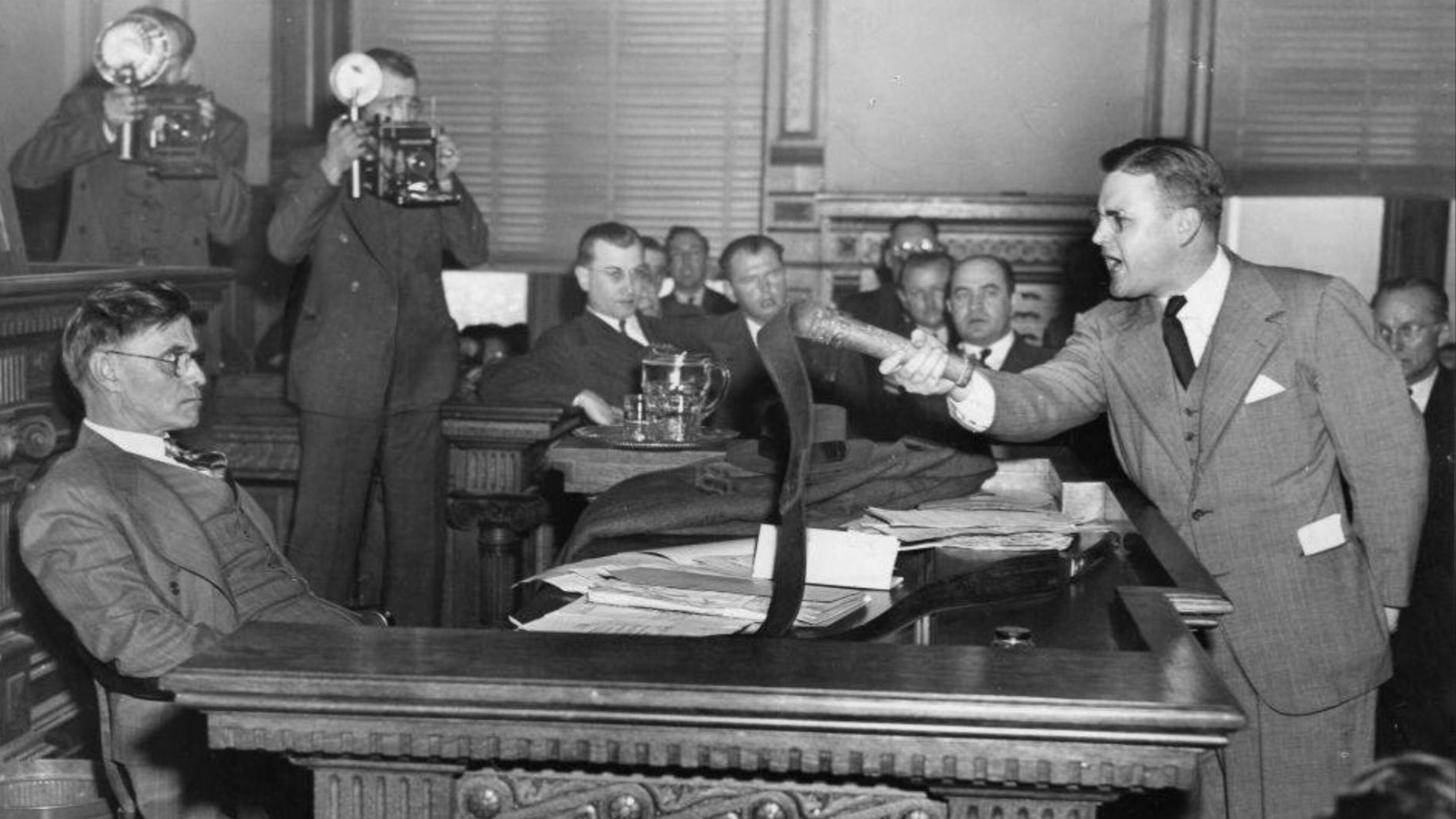 Attorney Dan Duke (right) confronts Georgia Gov. Eugene Talmadge in 1941 over the governor's desire to grant clemency to KKK members convicted of a series of assaults. Duke is holding a whip used by KKK members to beat Black people. (AJC file)