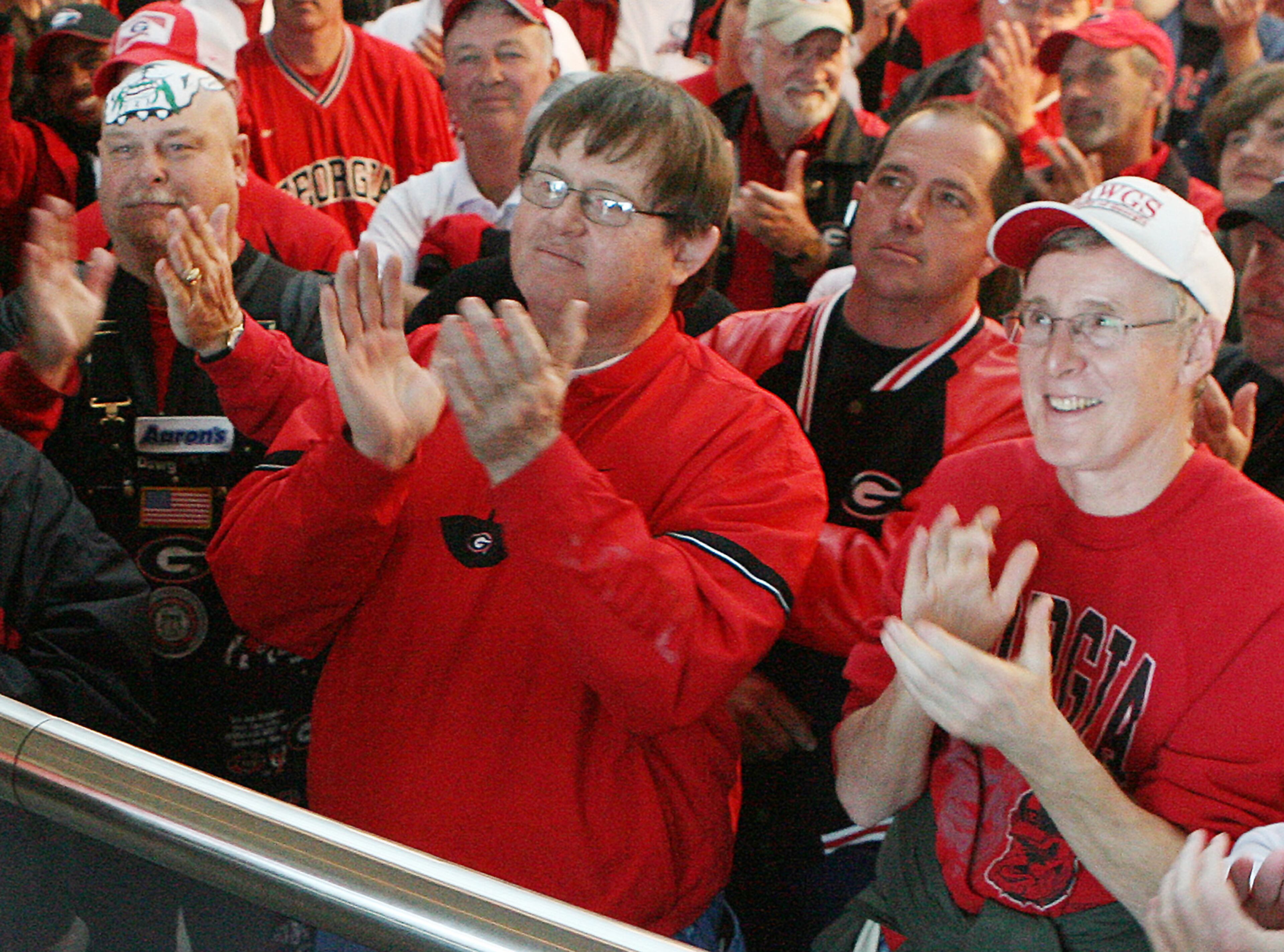 070207 - ATHENS, GA -- Fans (from left to right) Mike "Big Dog" Woods, 55 Colbert, Ga., Mike Peters, 56, Snellville, and Gordon Love, 62, Snellville, applaud as Georgia coach Mark Richt meets with fans on signing day at the Butts-Mehre Building in Athens, Ga., on Wednesday, February 7, 2007. (CURTIS COMPTON/ AJC staff)